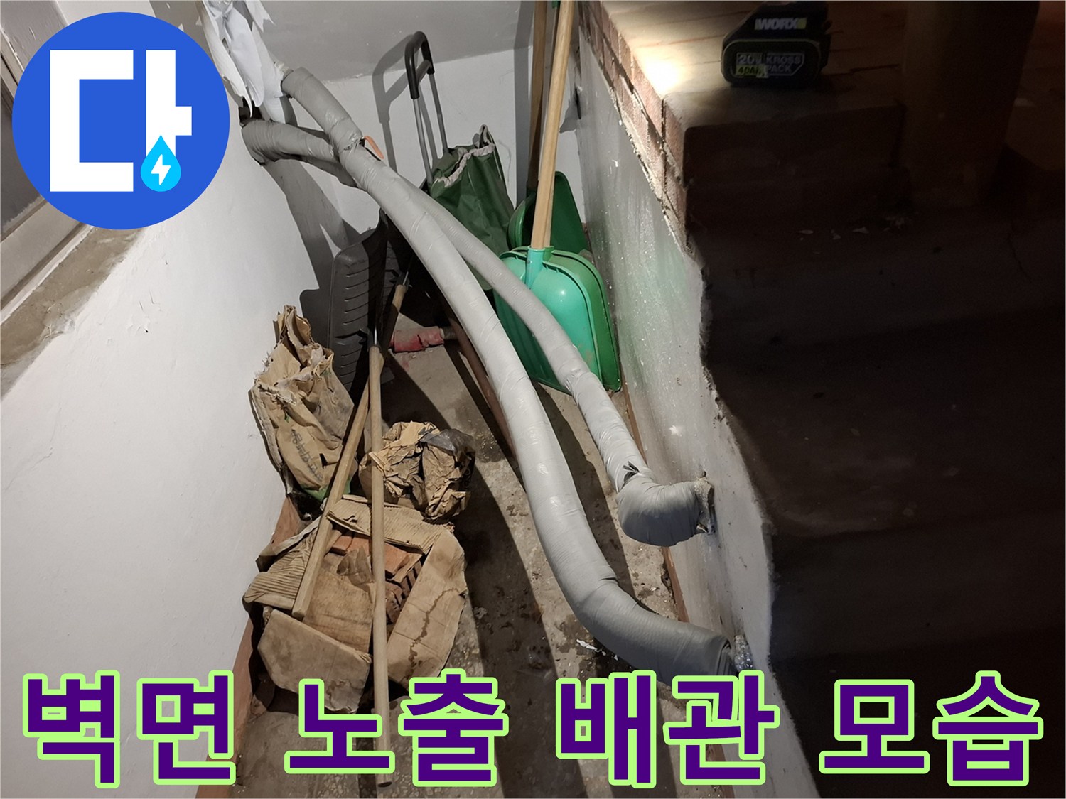 화장실 벽면에 설치된 회색 배관과 주변 자재