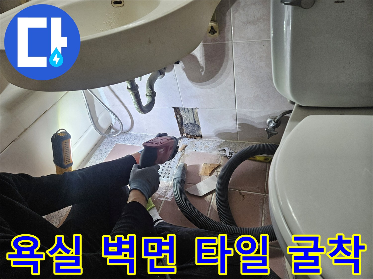 세면대 하단부의 타일을 제거하고 내부 배관을 노출시킨 공사 현장입니다.