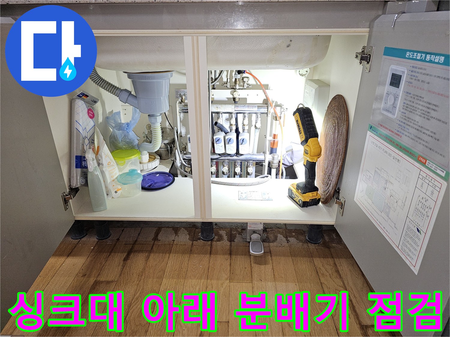 싱크대 하부장 내부의 복잡한 배관과 분배기 연결 부위 모습