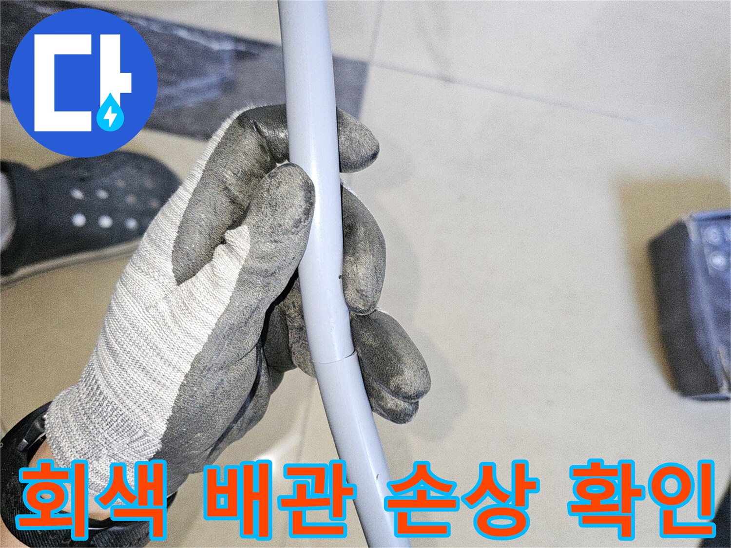 엔지니어가 회색 배관의 파손 부위를 점검하는 사진
