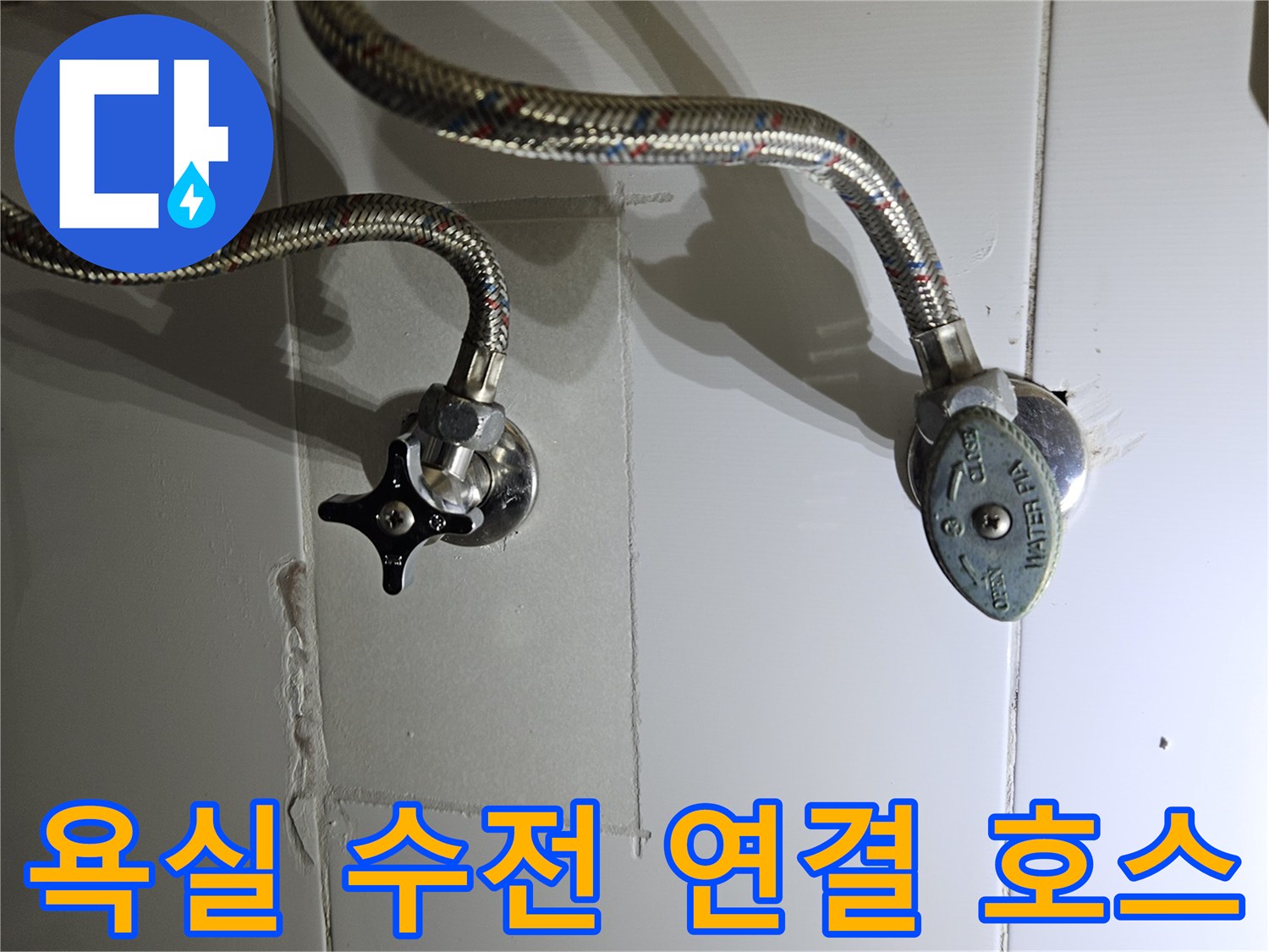 세면대 밑쪽 벽면에 설치된 온수 밸브와 연결 호스 상세 사진