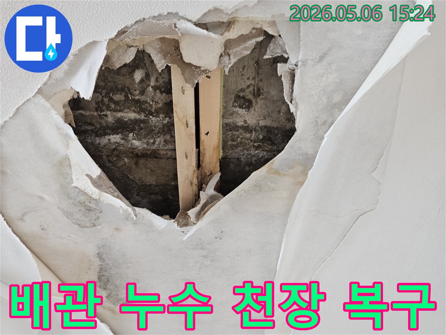 배관 누수로 인해 천장 벽지가 젖고-찢어져 내부 구조물이 드러난 심각한 피해 현장입니다.