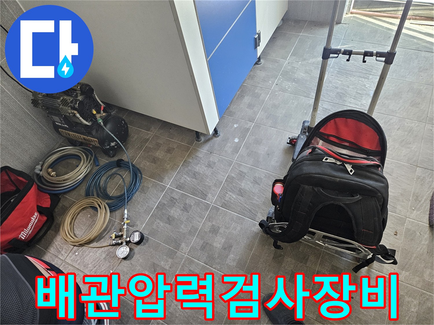 누수 탐지를 위한 핵심 장비인-콤프레셔와 정밀 압력 게이지-그리고 다양한 연결 호스들이-작업 현장에 준비된 모습