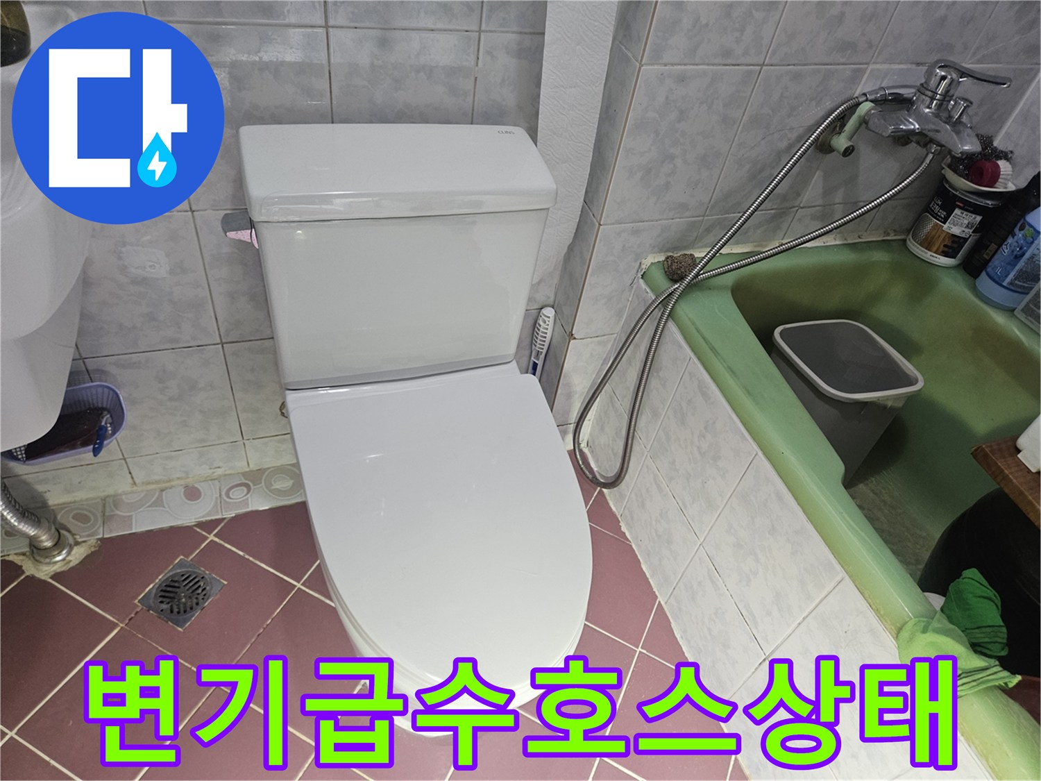 화장실 변기 뒤쪽 급수 밸브와 연결 호스의 근접 사진