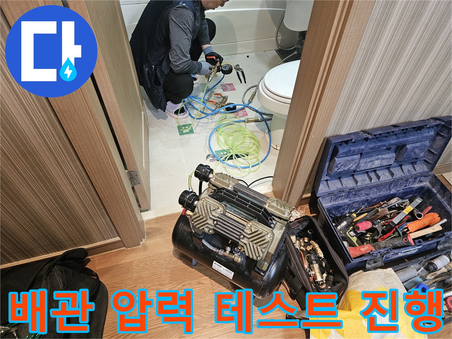 변기 근처 배관에 연결된 공기압 테스트용 호스와 장비 모습