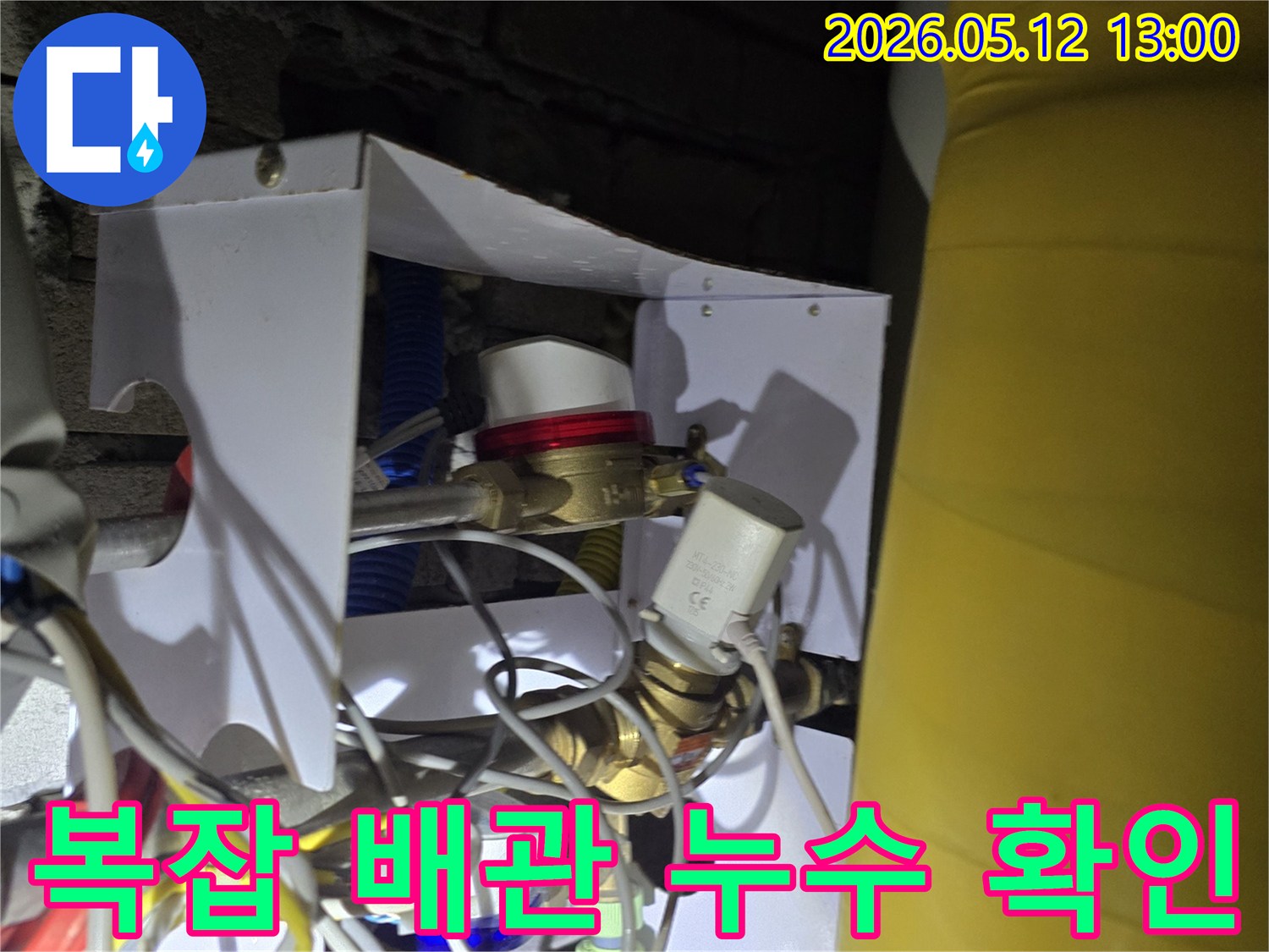 어두운 공간 속 복잡하게 얽힌 배관에서 누수 지점을 찾는 모습-정확한 진단을 위한 전문가의 면밀한 탐지 작업