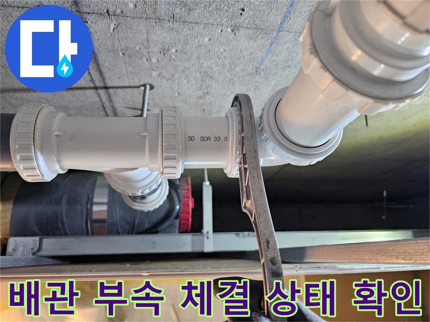 스패너를 사용하여 하수 배관의 연결 부위를 조절하는 모습