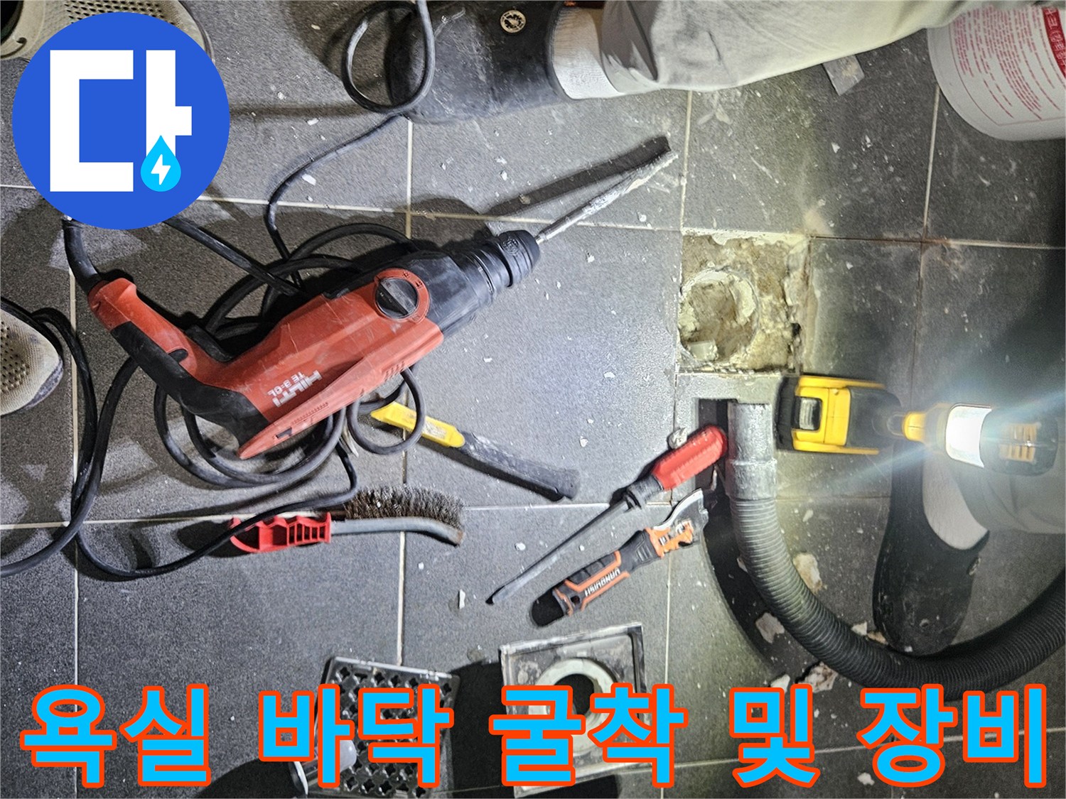 굴착 작업 중 사용된 전동 드릴과 배관 점검을 위한 공구들이 놓여 있습니다.