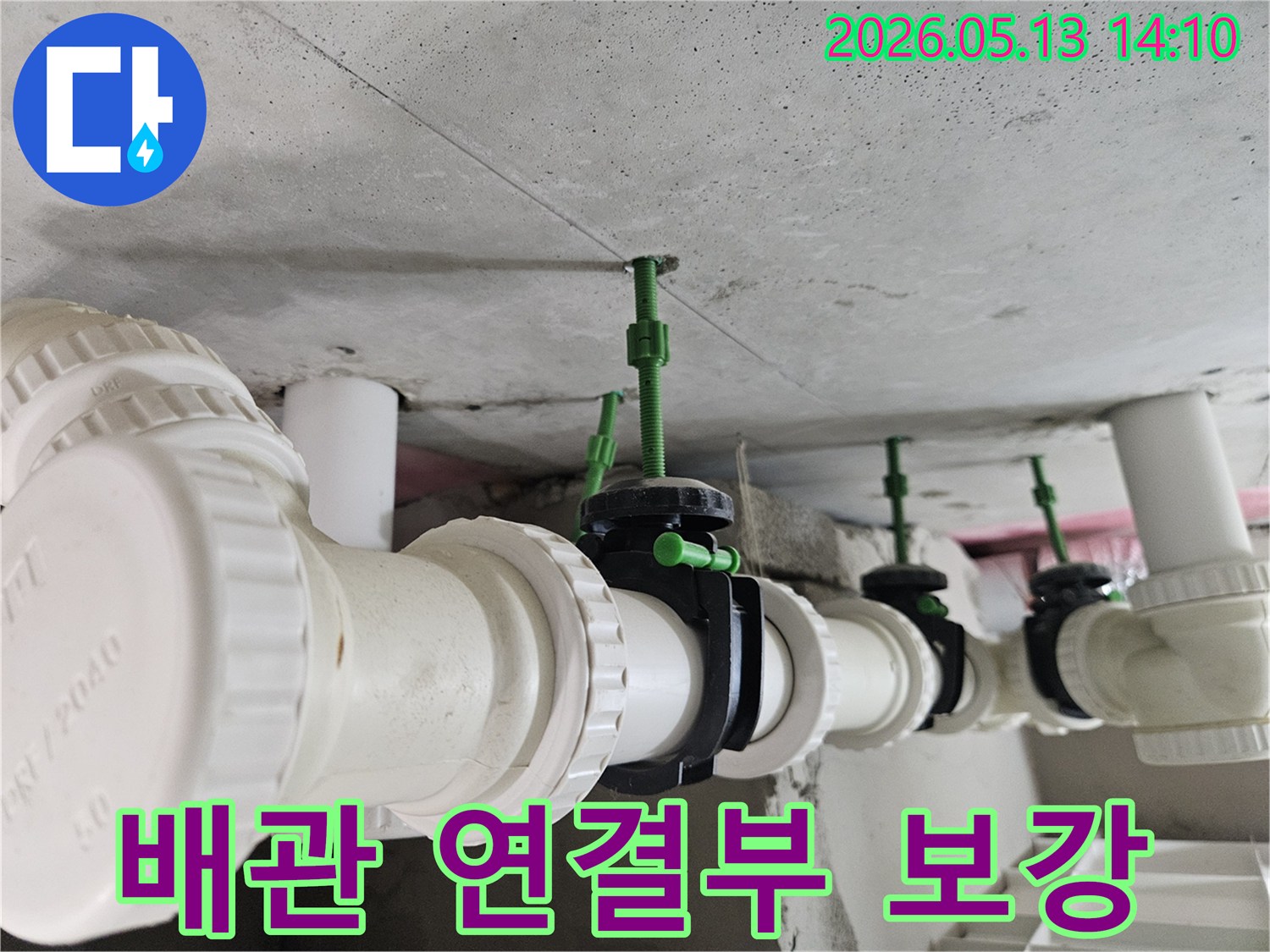 콘크리트 천장에 단단히 고정된 흰색 배관과-검은색 연결 밸브의 견고한 모습