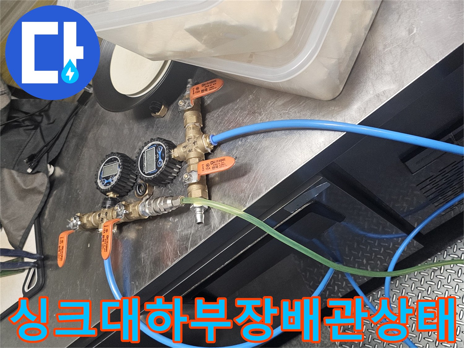 싱크대 하단에 설치된 수전 밸브와 급수 호스 배열