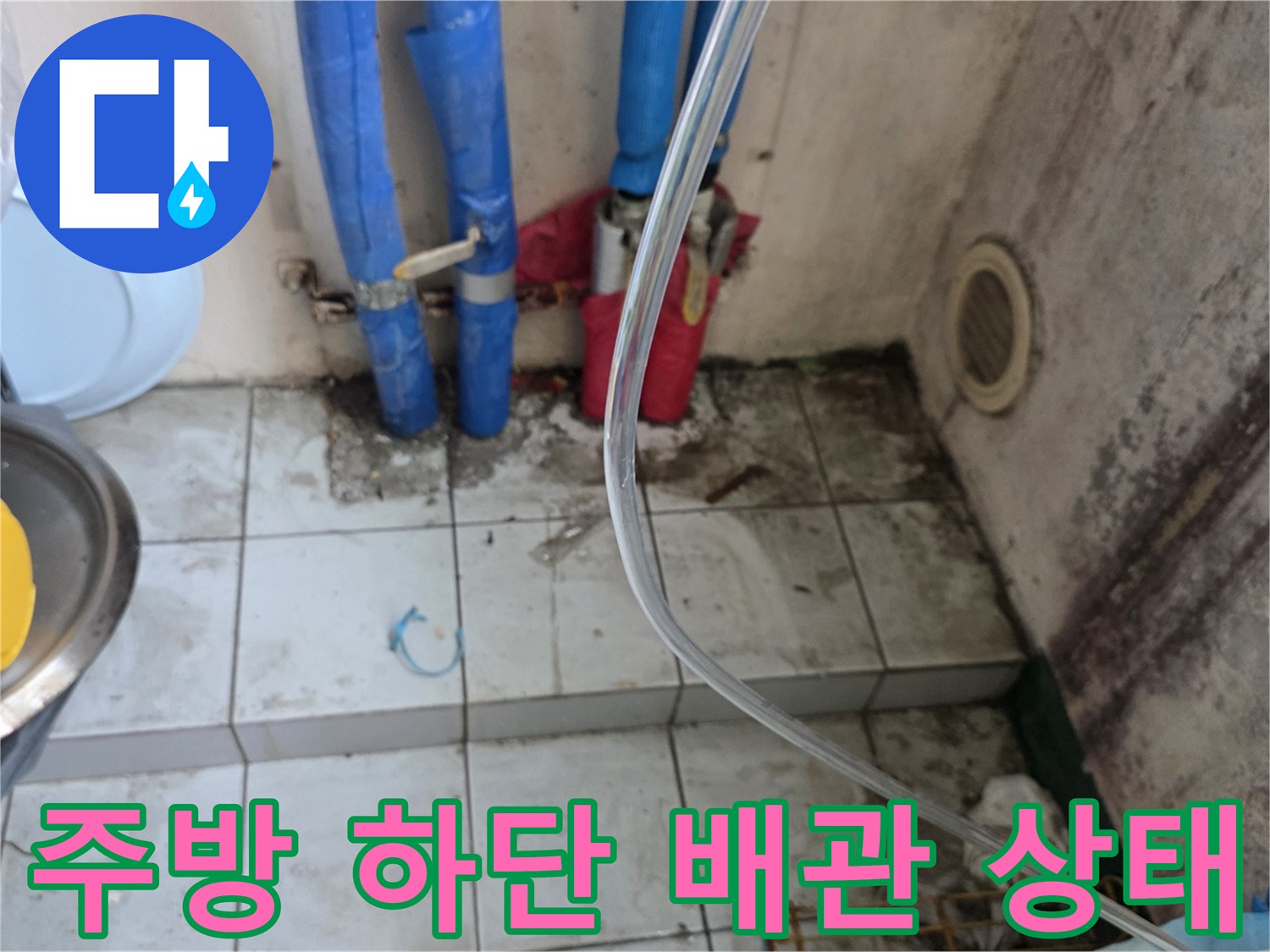 싱크대 아래쪽 파란색 배관과 젖은 타일 면을 나타낸 사진입니다.
