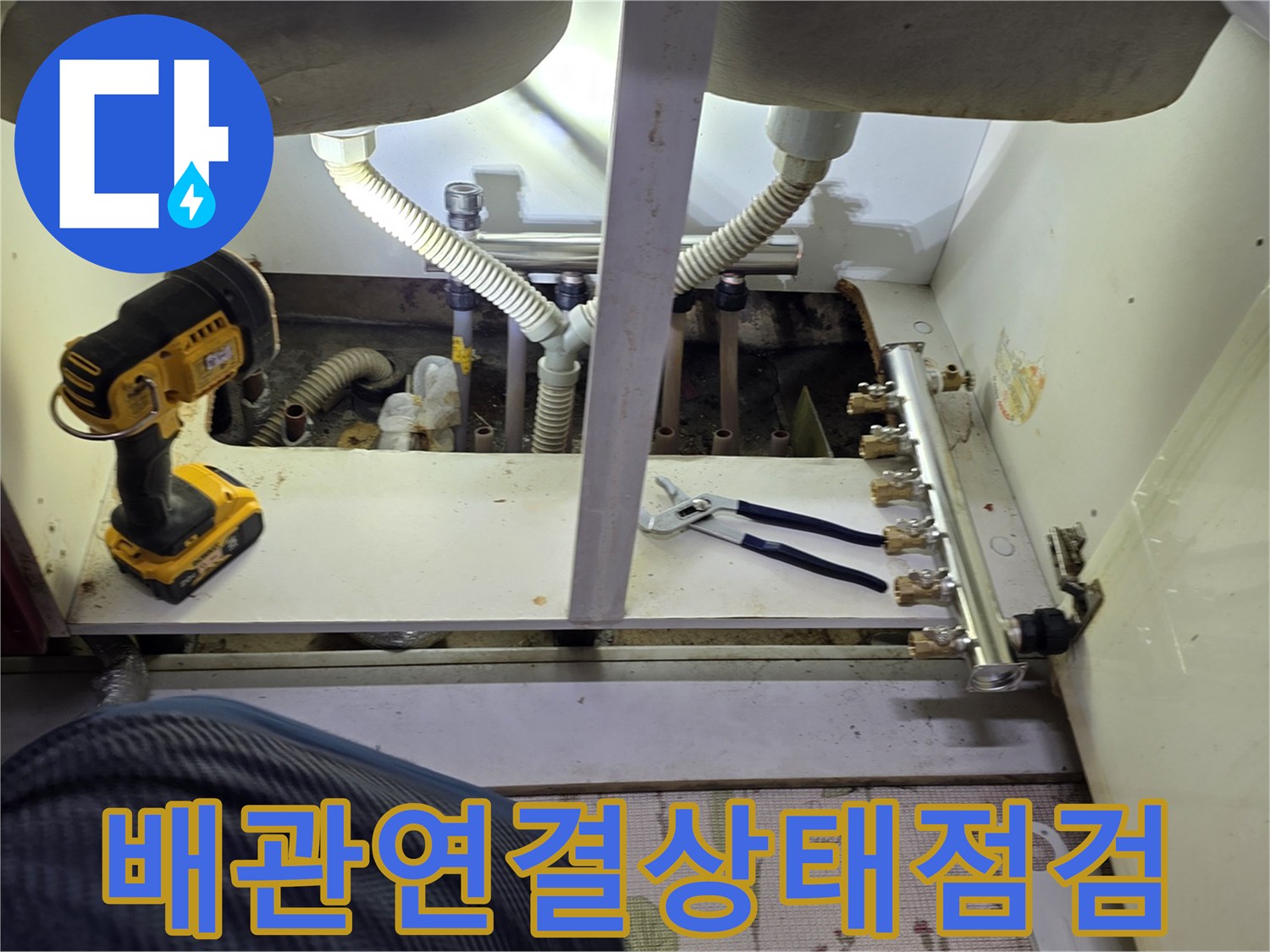 싱크대 하단 분배기 밸브와 배관의 체결 상태를 점검하는 모습