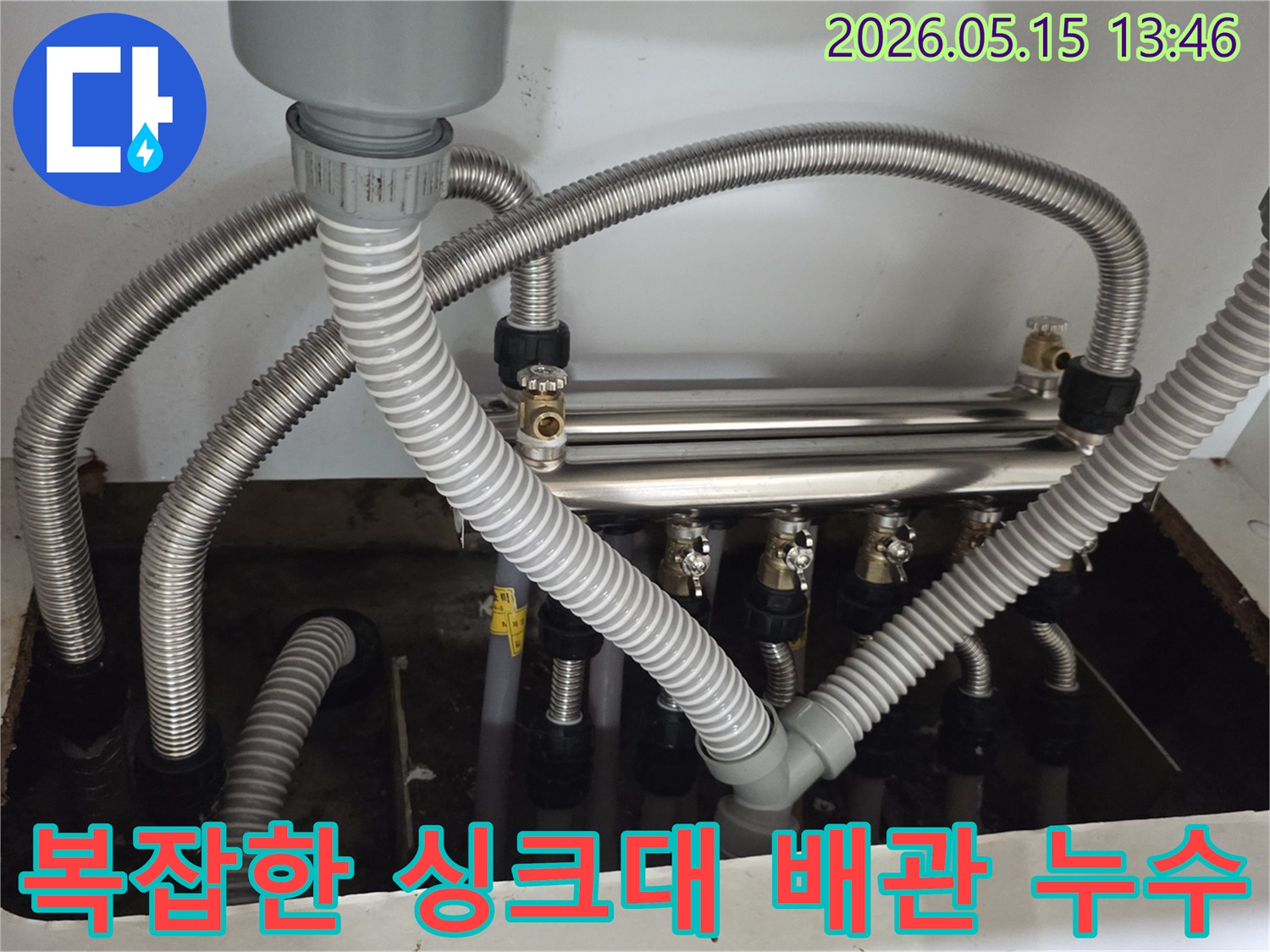 싱크대-하부의-여러-배관들이-복잡하게-연결되어-있고-그-사이에서-누수가-발생한-모습입니다