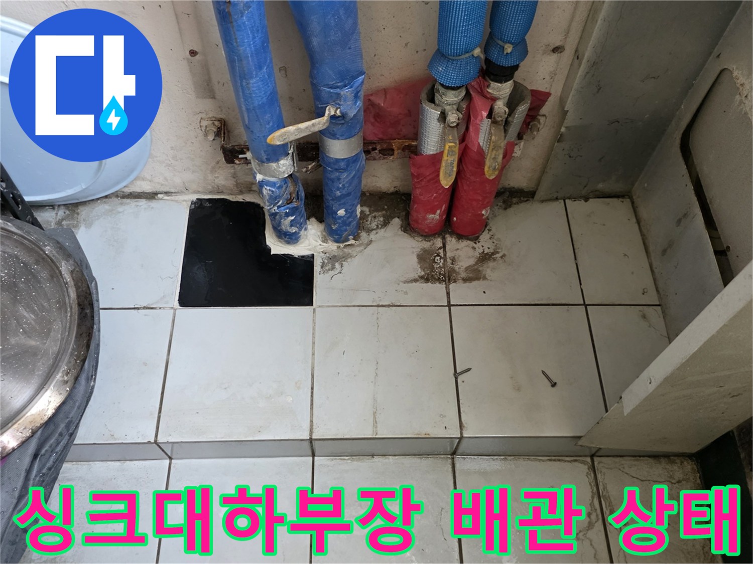 주방 싱크대 하단 - 보일러 분배기와 연결된 배관 점검 모습