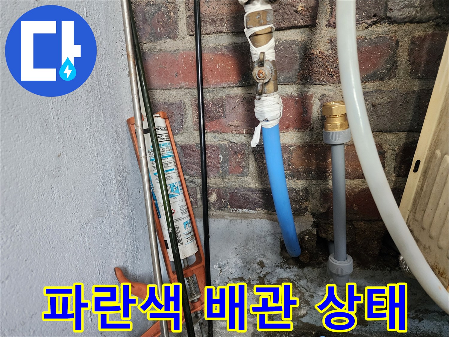 벽돌 벽면에 연결된-파란색 PB배관과 보수용 실란트