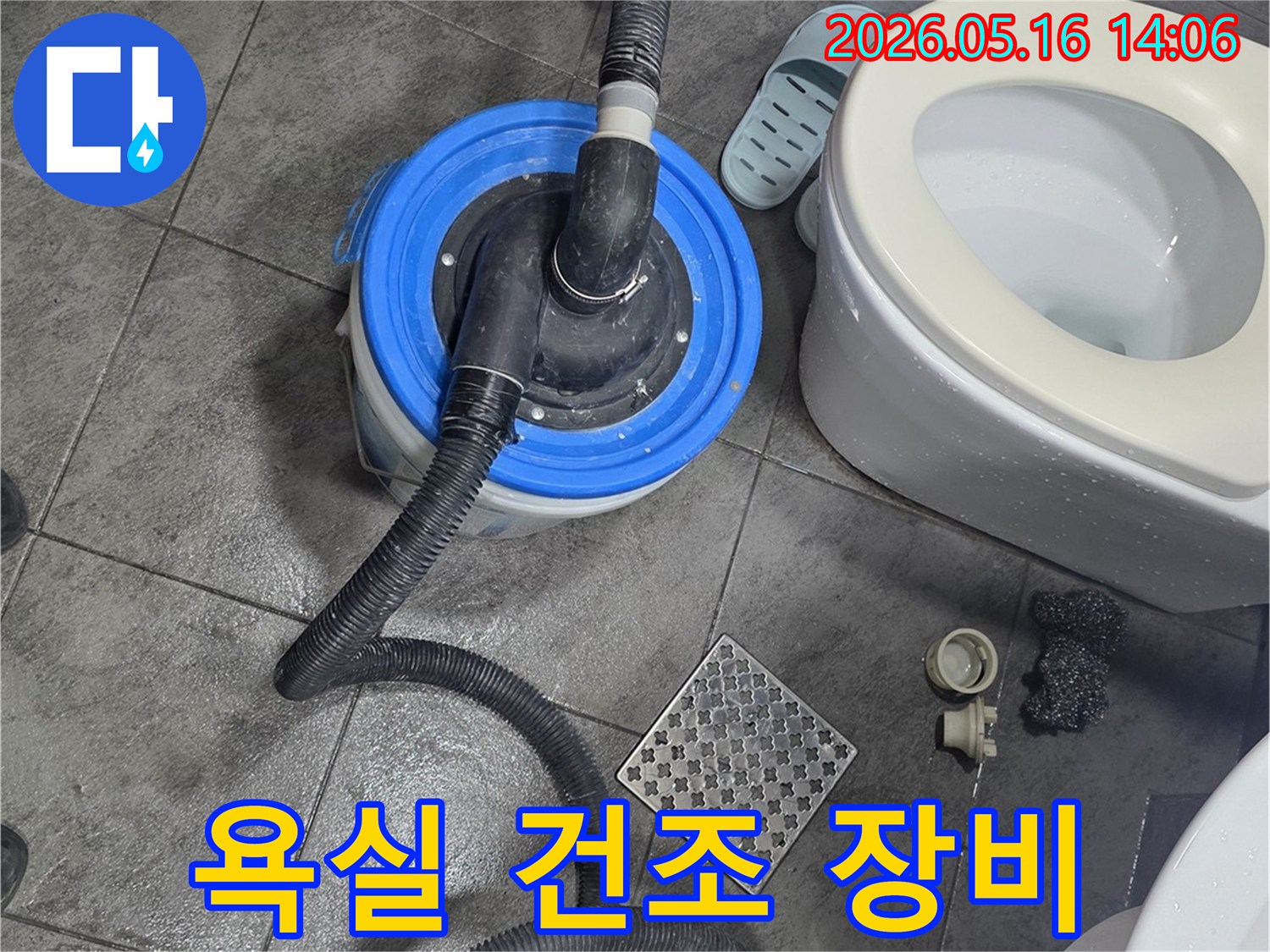 욕실 바닥에-놓인 전문 건조 장비와-변기-그리고 젖은 타일의-누수 복구 작업 현장 모습