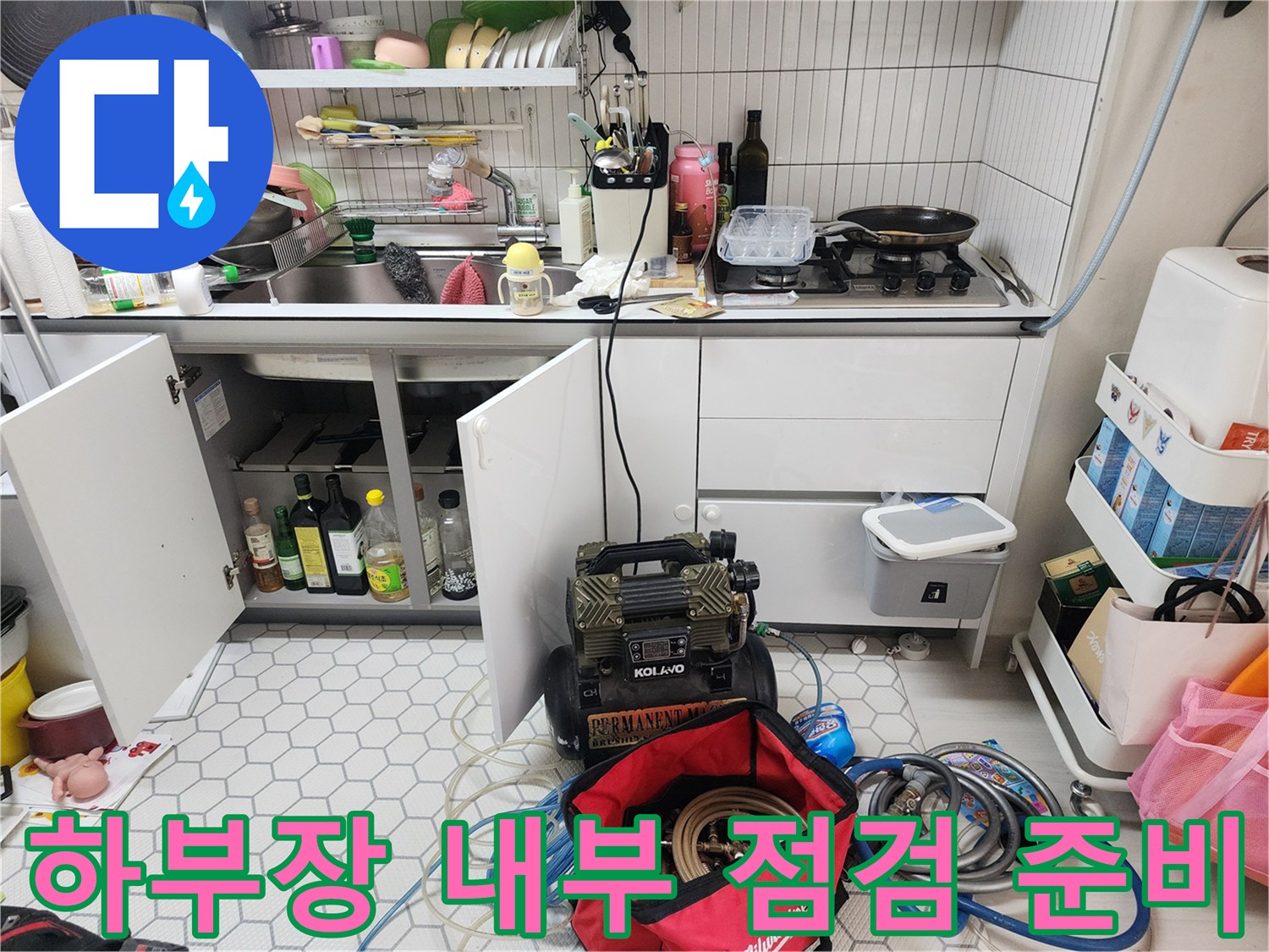 싱크대 밑 공간에 놓여 있는 누수 탐지용 장비 세트