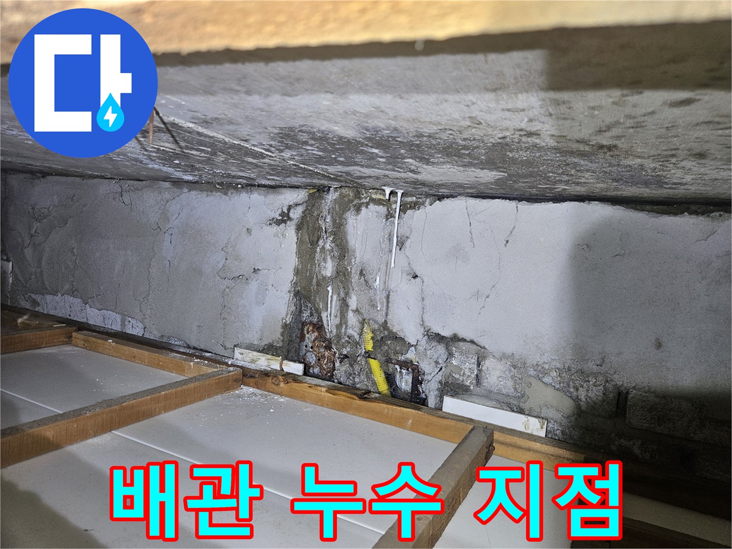 벽체 틈새에 노출된 부식된 배관과 습기 흔적