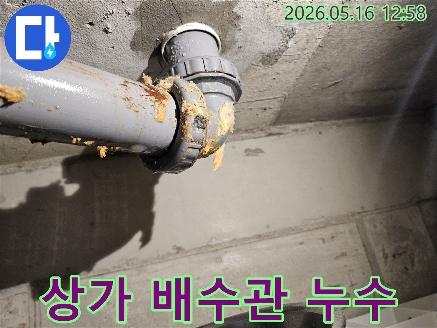 상가-건물-천장-아래-배수관-연결부에서-물이-새어-나와-단열재가-젖은-모습을-보여주는-누수-현장-사진