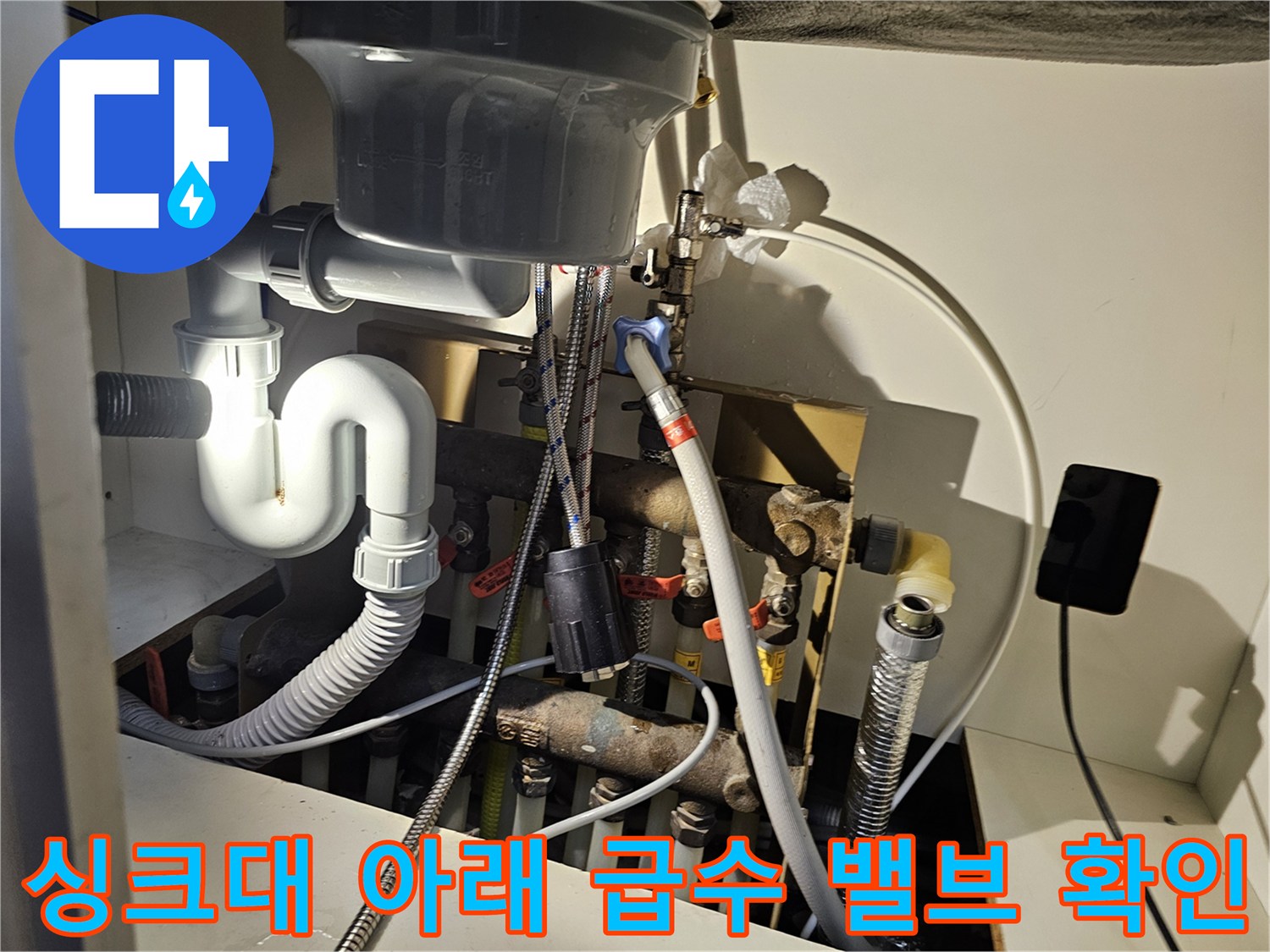 복잡하게 연결된 싱크대 하부 급수 및 배수 배관 구조