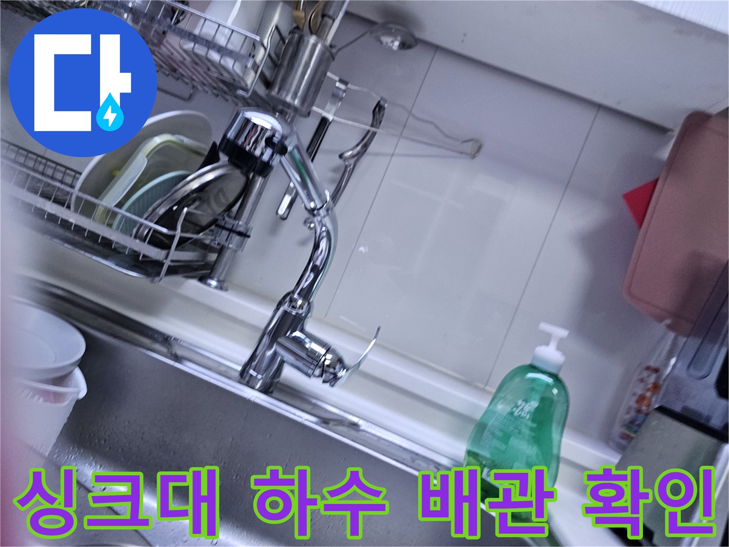 싱크대 하부 틈새로 보이는 배수 호스와 연결 부위 상세 사진