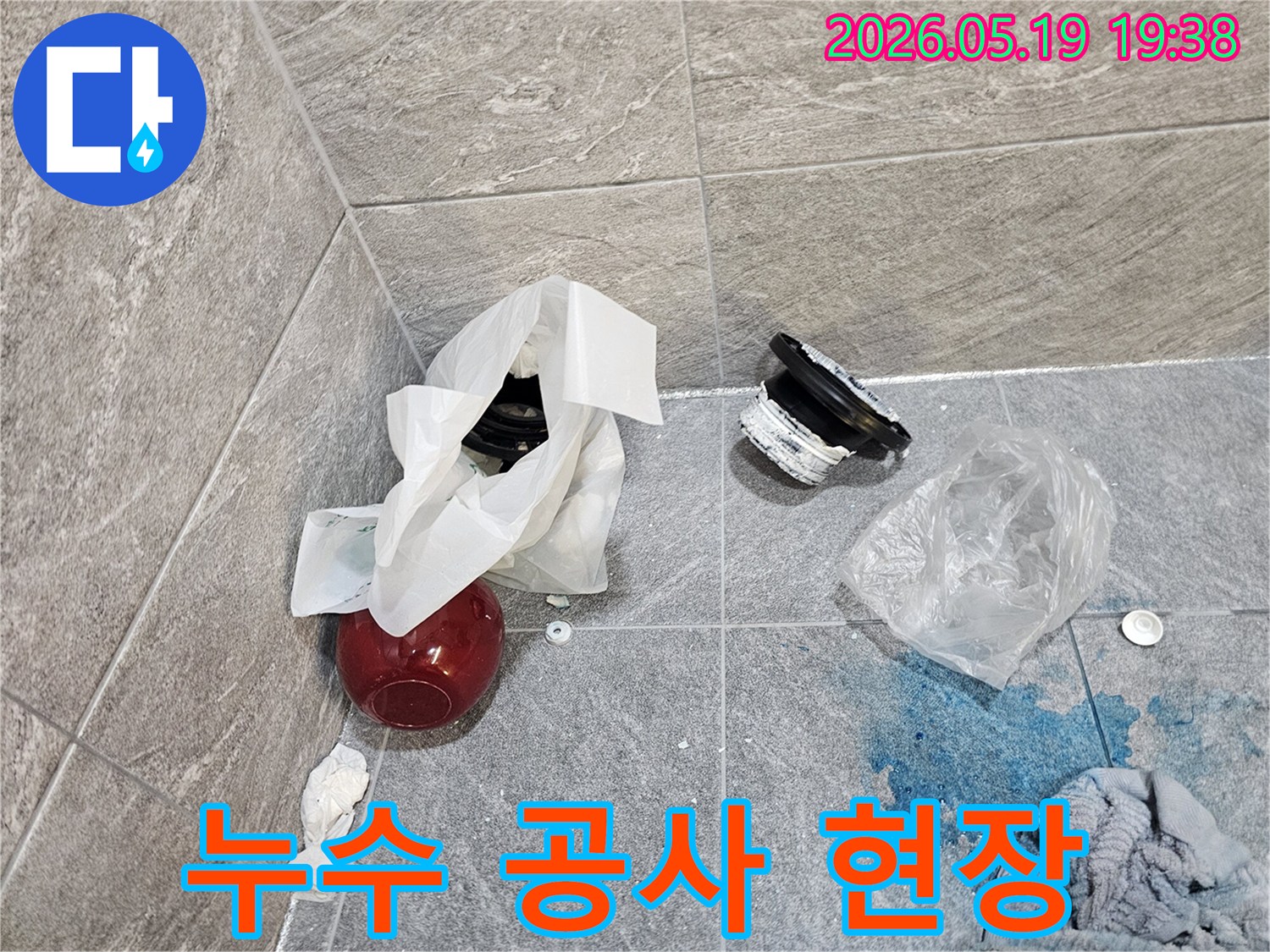 누수 공사 중인 욕실의 모습-제거된 배관 부품과-염료로 확인된 누수 지점