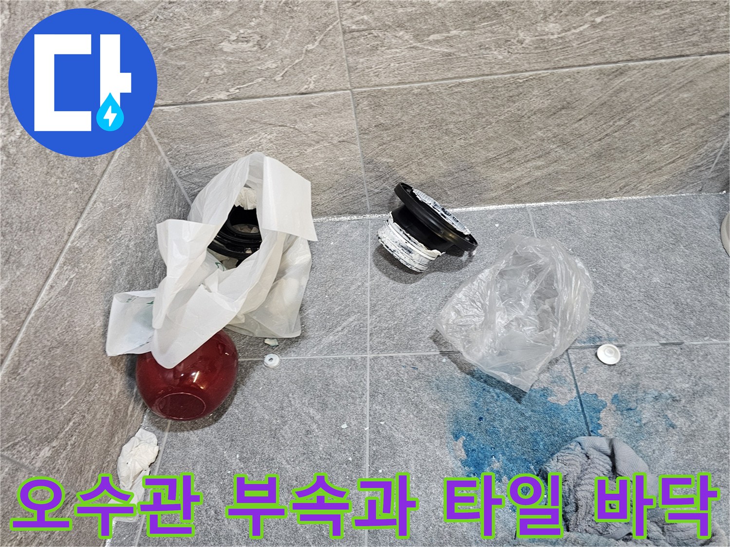 분리된 배관 부속과 물기가 남은 욕실 타일 현장입니다.