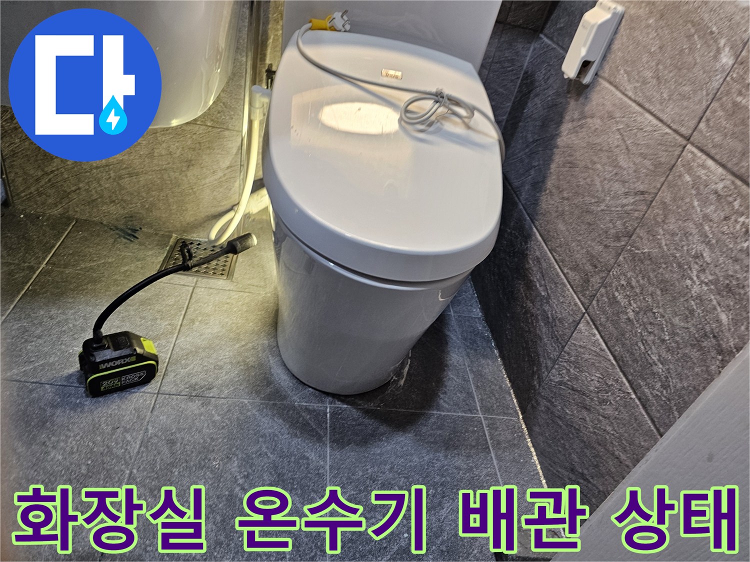 화장실 벽면에 설치된 온수기와 하단 배관 연결 부위의 모습입니다.