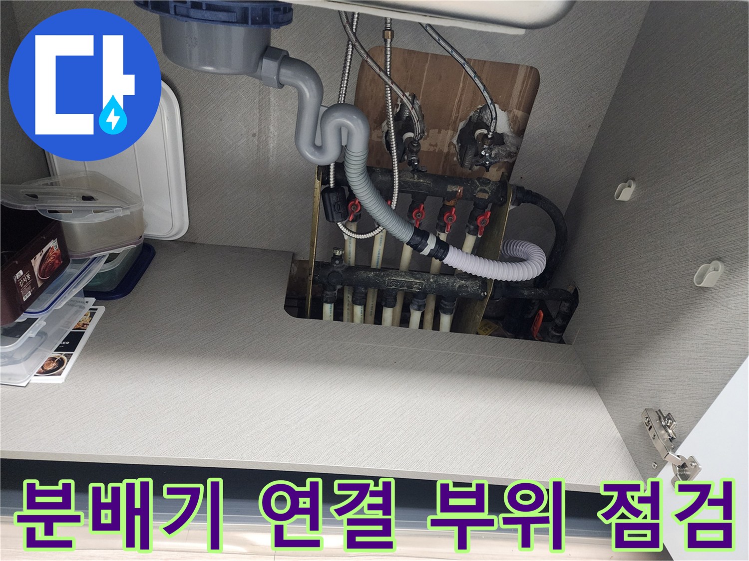 싱크대 아래 공간-분배기와 배관의 접합부를 집중적으로 촬영한 이미지