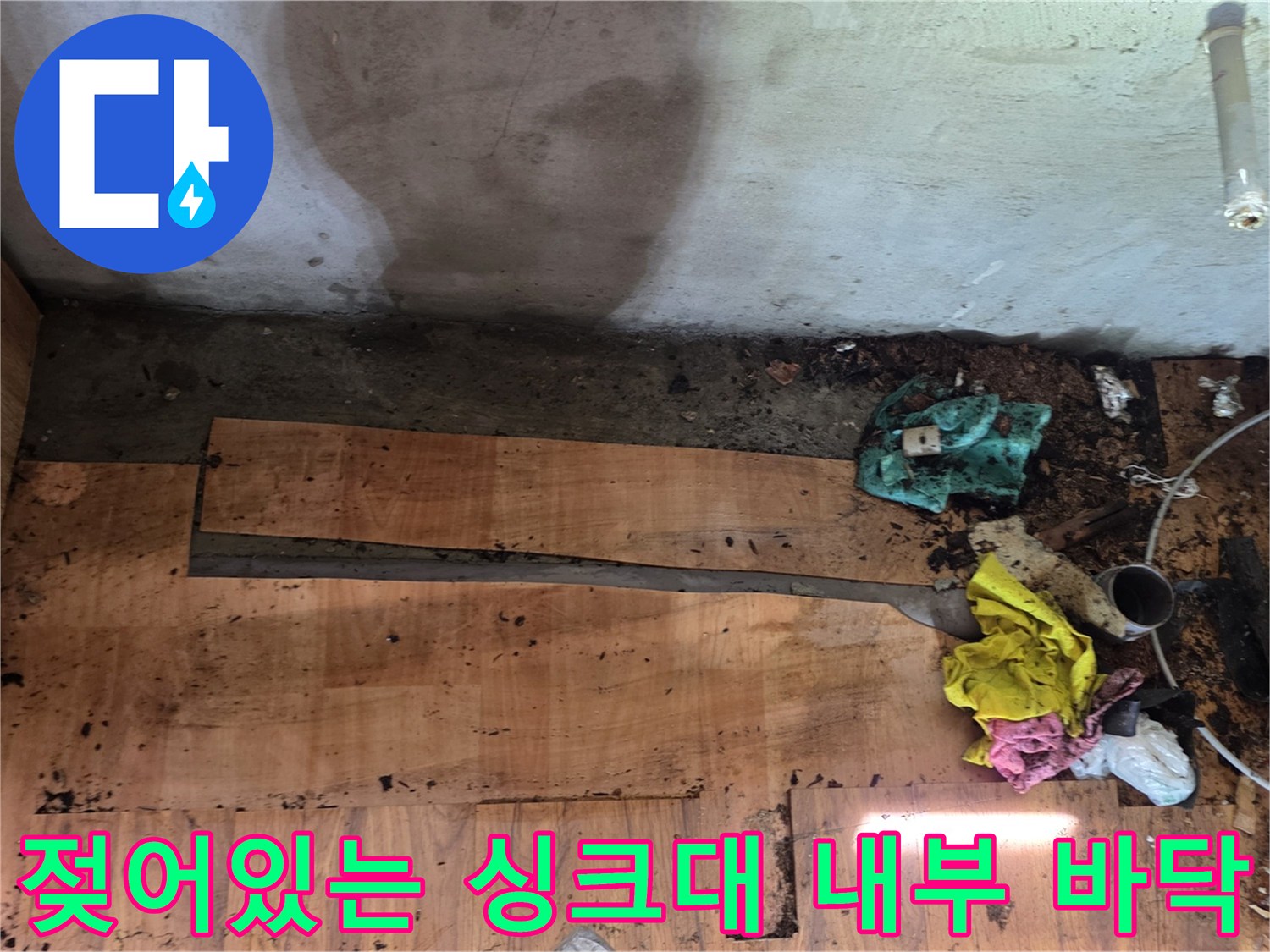 누수가 발생하여 물에 젖은 상태의 싱크대 하부 바닥재