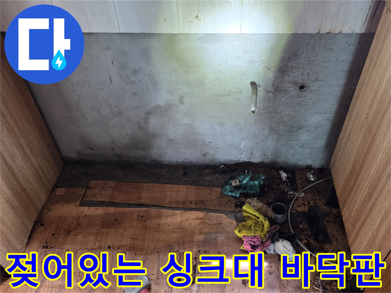 싱크대 내부 바닥-누수로 인해 부풀어 오른 합판과 오염된 부위