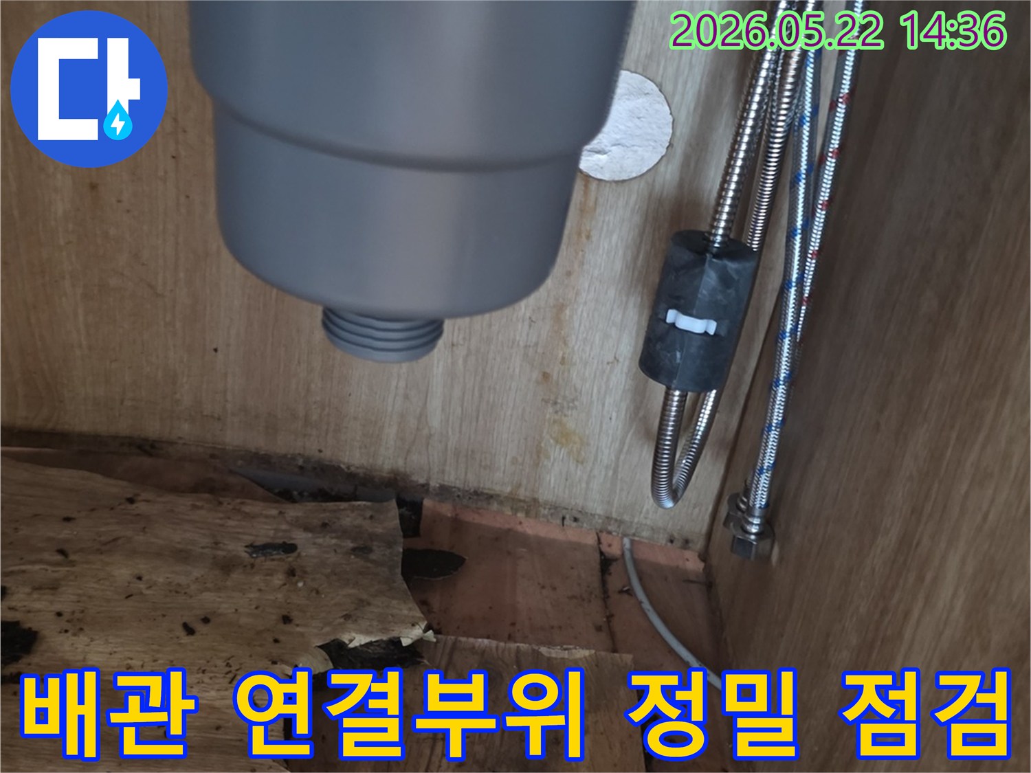 싱크대 하부장 내부의 물샘 흔적과-손상된 목재-그리고 배관 연결 부위를-전문가가 정밀하게 점검하는 현장 사진