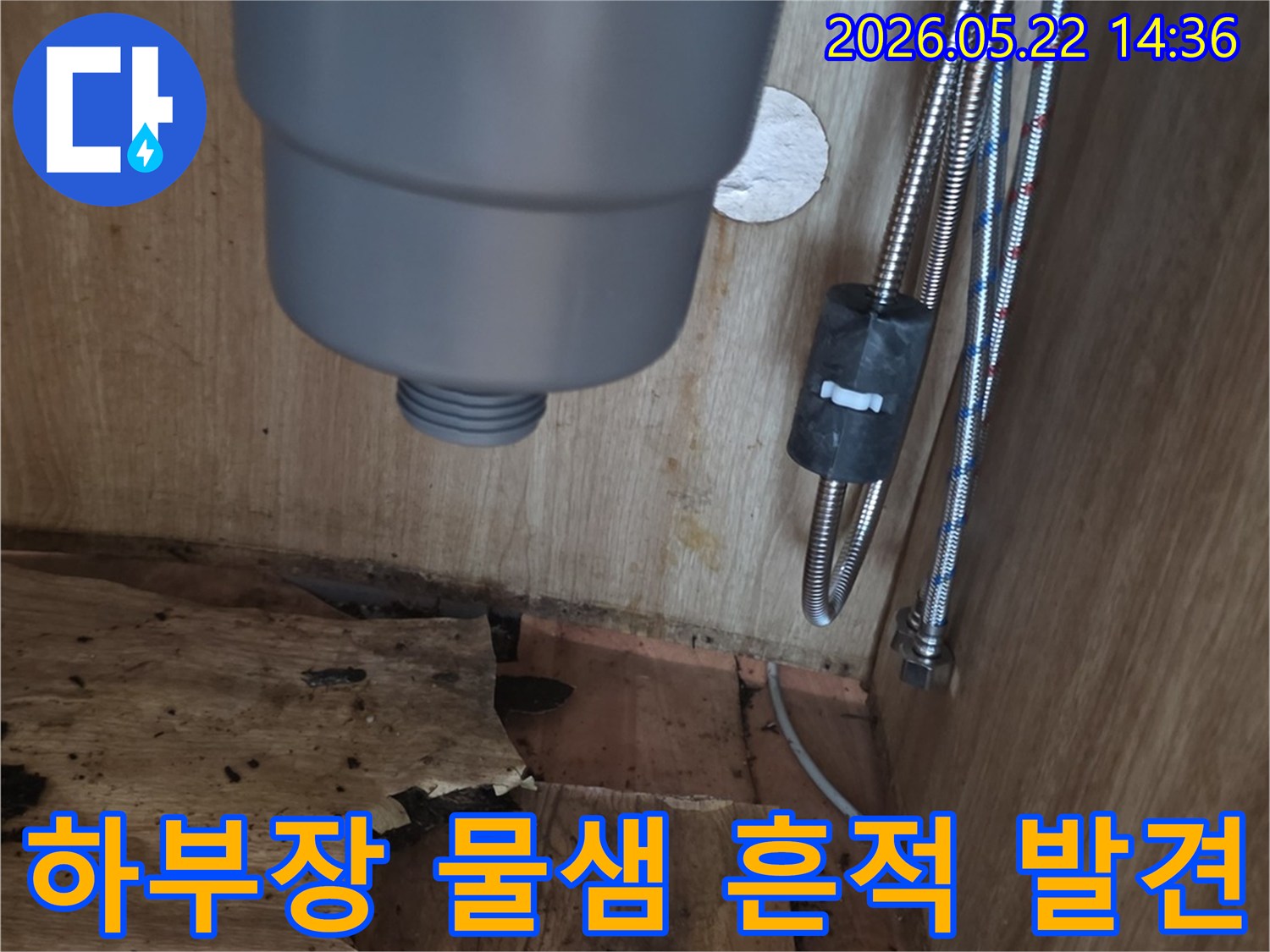 싱크대 하부장 바닥과 벽면의-심각한 물샘 흔적과-손상된 목재를 보여주는 누수 현장 사진