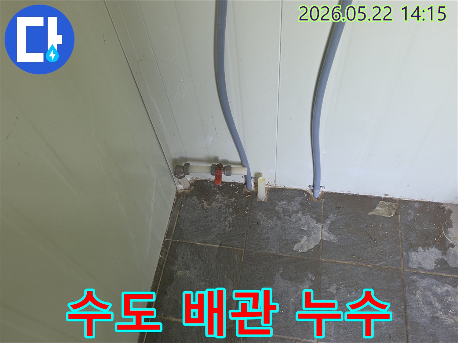 포천 금현리 현장에서-수도 배관 연결부의-붉은 밸브 주변으로-물기가 스며들어-타일이 젖은 모습을-보여주는 사진