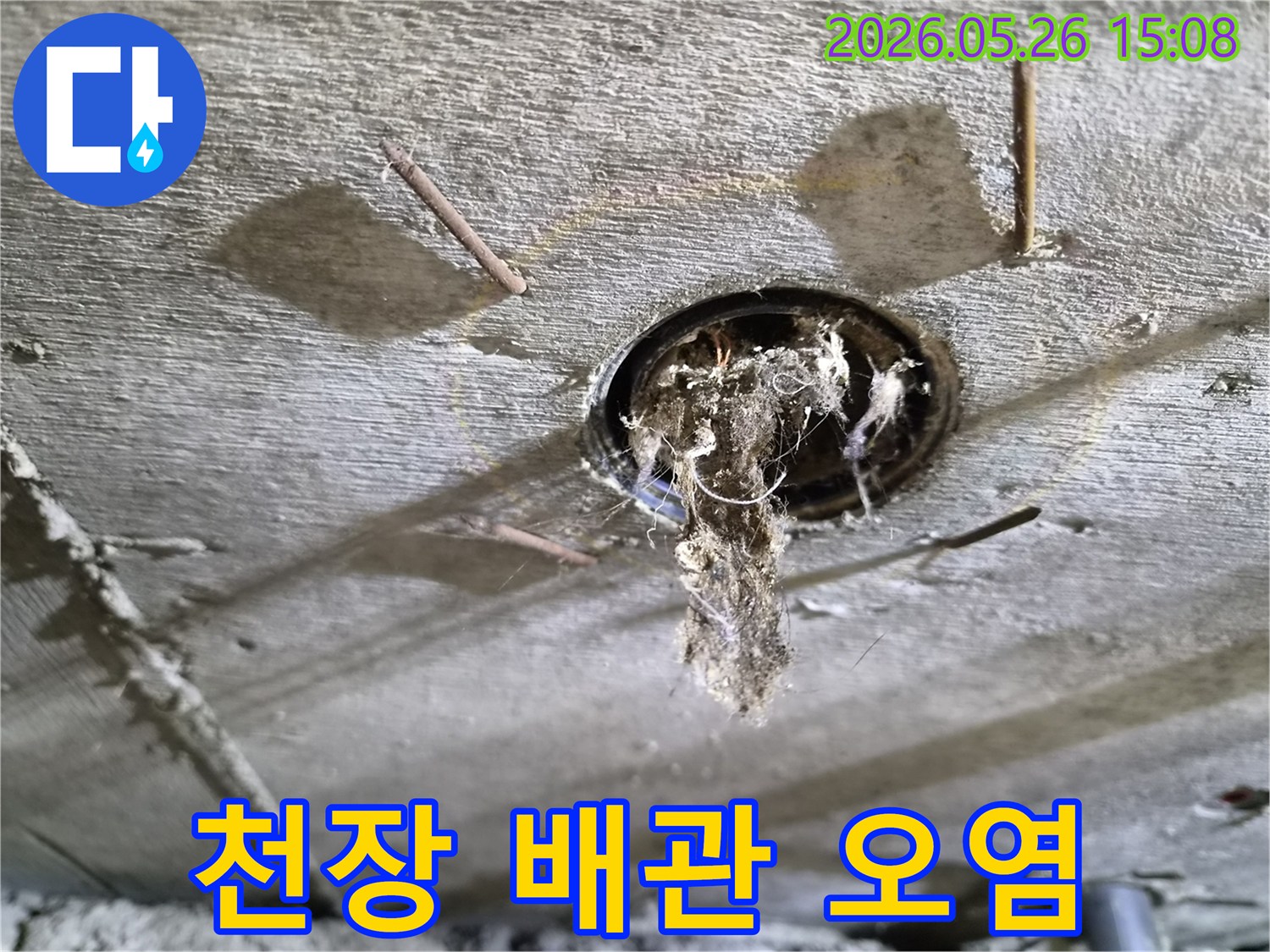 콘크리트 천장 구멍에서-배관 문제로-인해-오염된 이물질이-떨어지는-누수-현장의-상황을-보여주는-사진