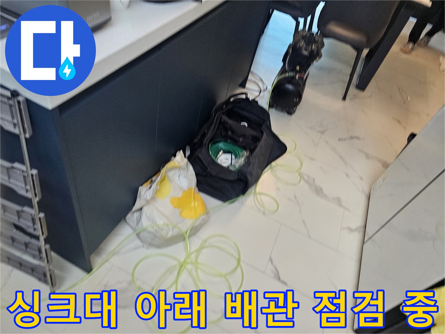 작업을 위해 싱크대 밑에 배치된 각종 배관 자재와 도구