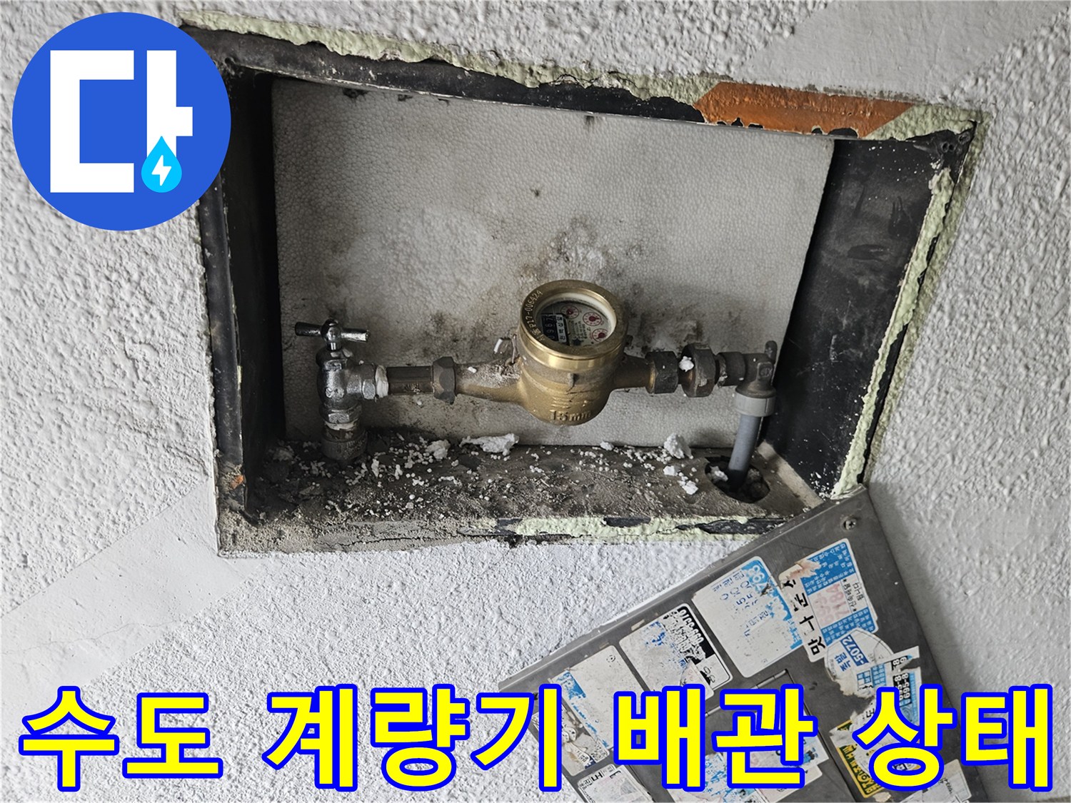 수도 계량기와 연결된 금속 배관의 상태를 점검하는 장면입니다.