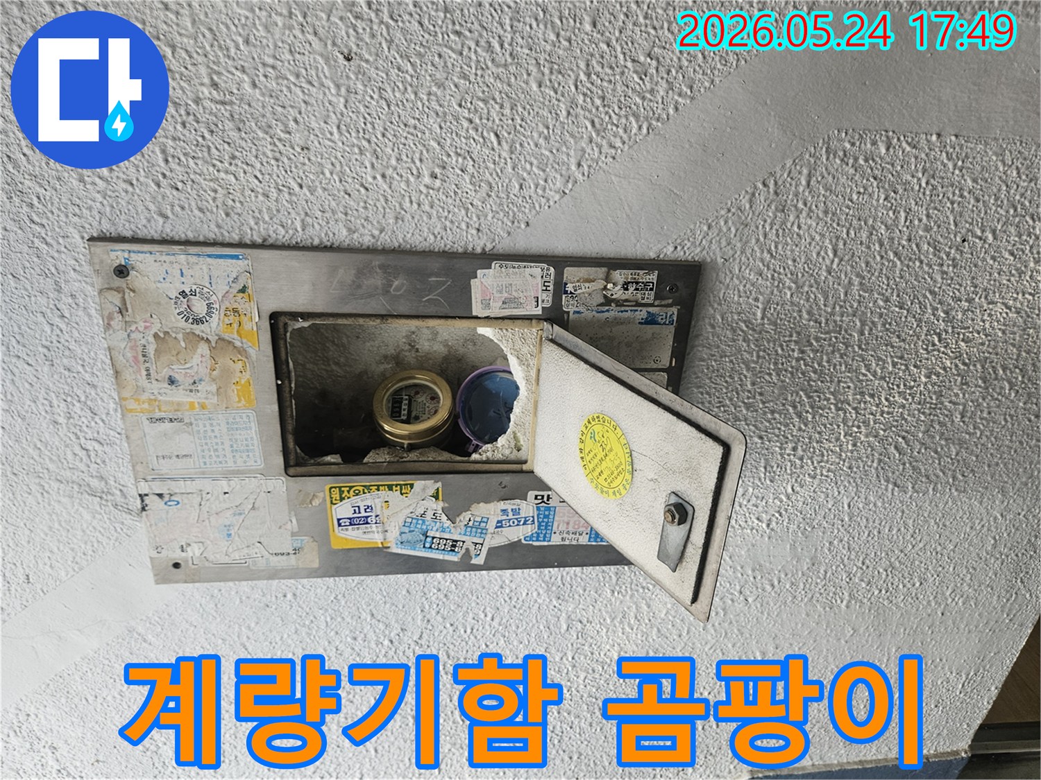 수도계량기함 주변 벽면에-곰팡이가 피어있는 모습으로-누수로 인한 습기 문제를 보여줍니다.
