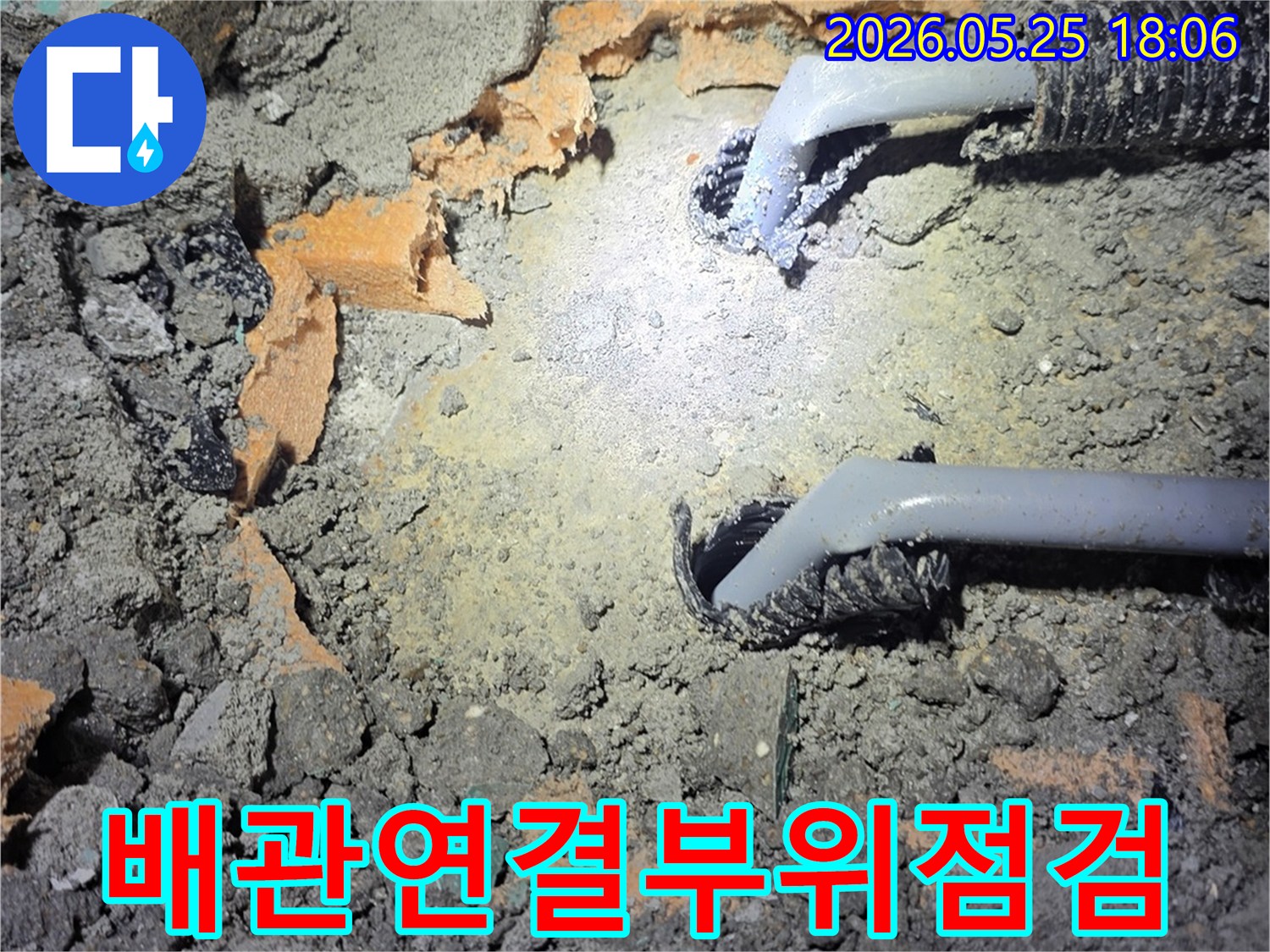 벽면-속-노출된-배관의-연결-부위를-집중적으로-살펴보며-누수-여부를-점검하고-있습니다