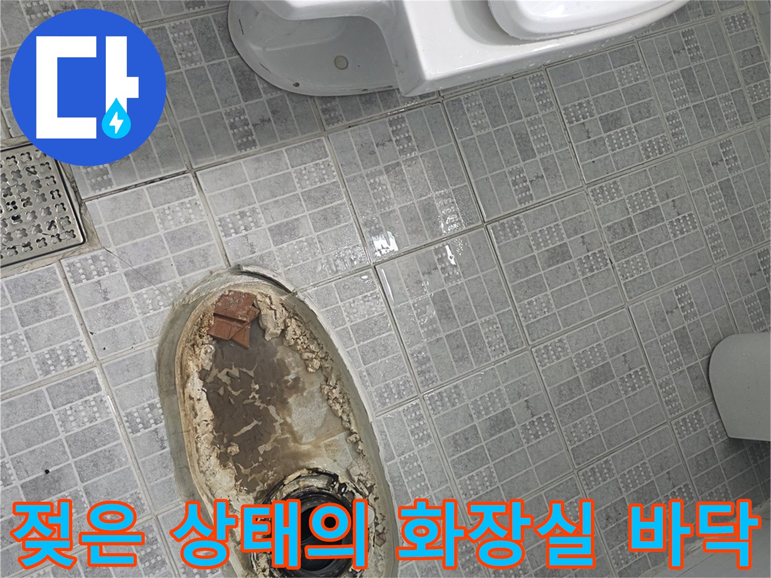 배수구 주변 타일이 물에 젖어 어둡게 변한 모습