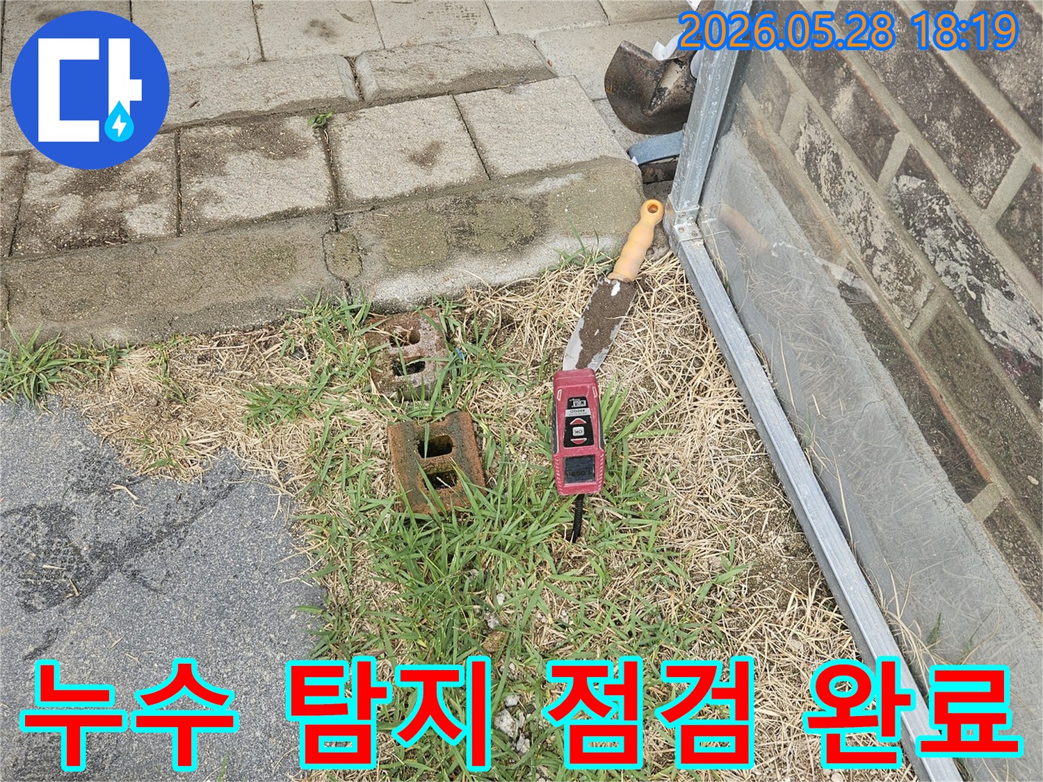 주택 누수 탐지를 위해-삽과 정밀 수평계 같은 필수 장비들이 현장에 세팅된 모습으로-점검을 완료했습니다
