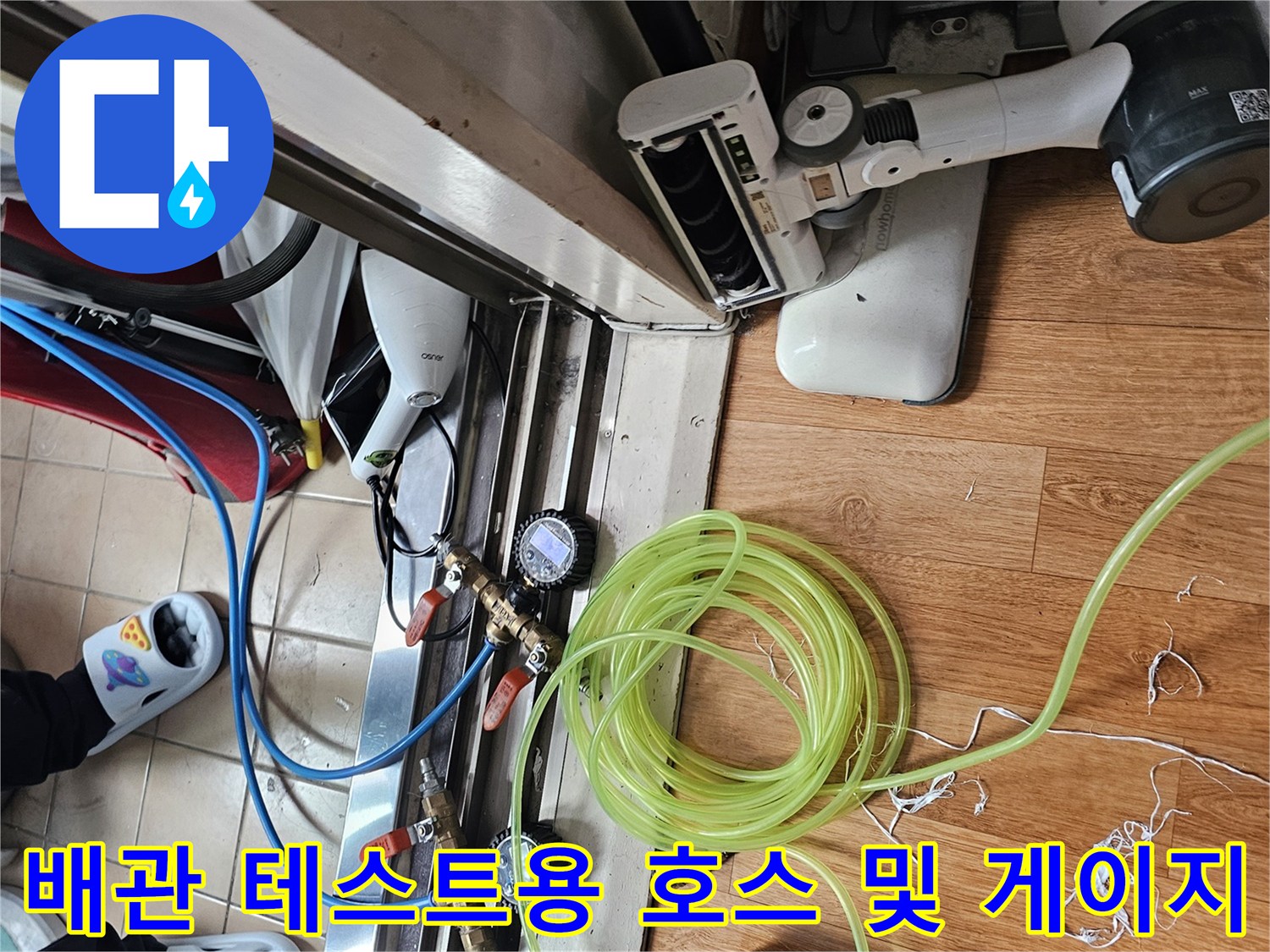 싱크대 하부 누수 진단-공압 검사를 위한 압력계와 연결된 노란색 호스