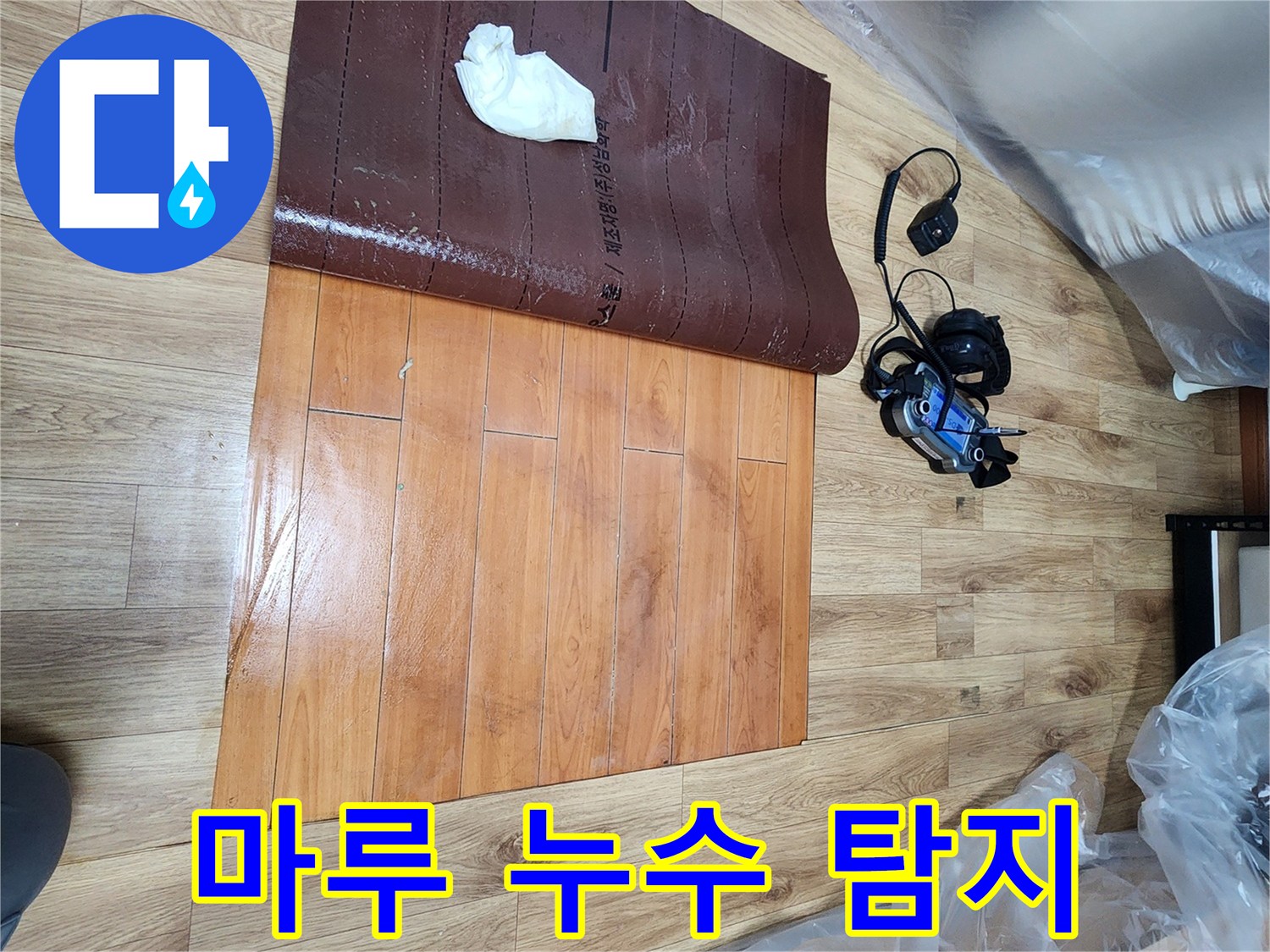 누수-탐지-전문가가-남동구-주택-누수-현장에서-마루-아래-물기를-확인하는-장면입니다
