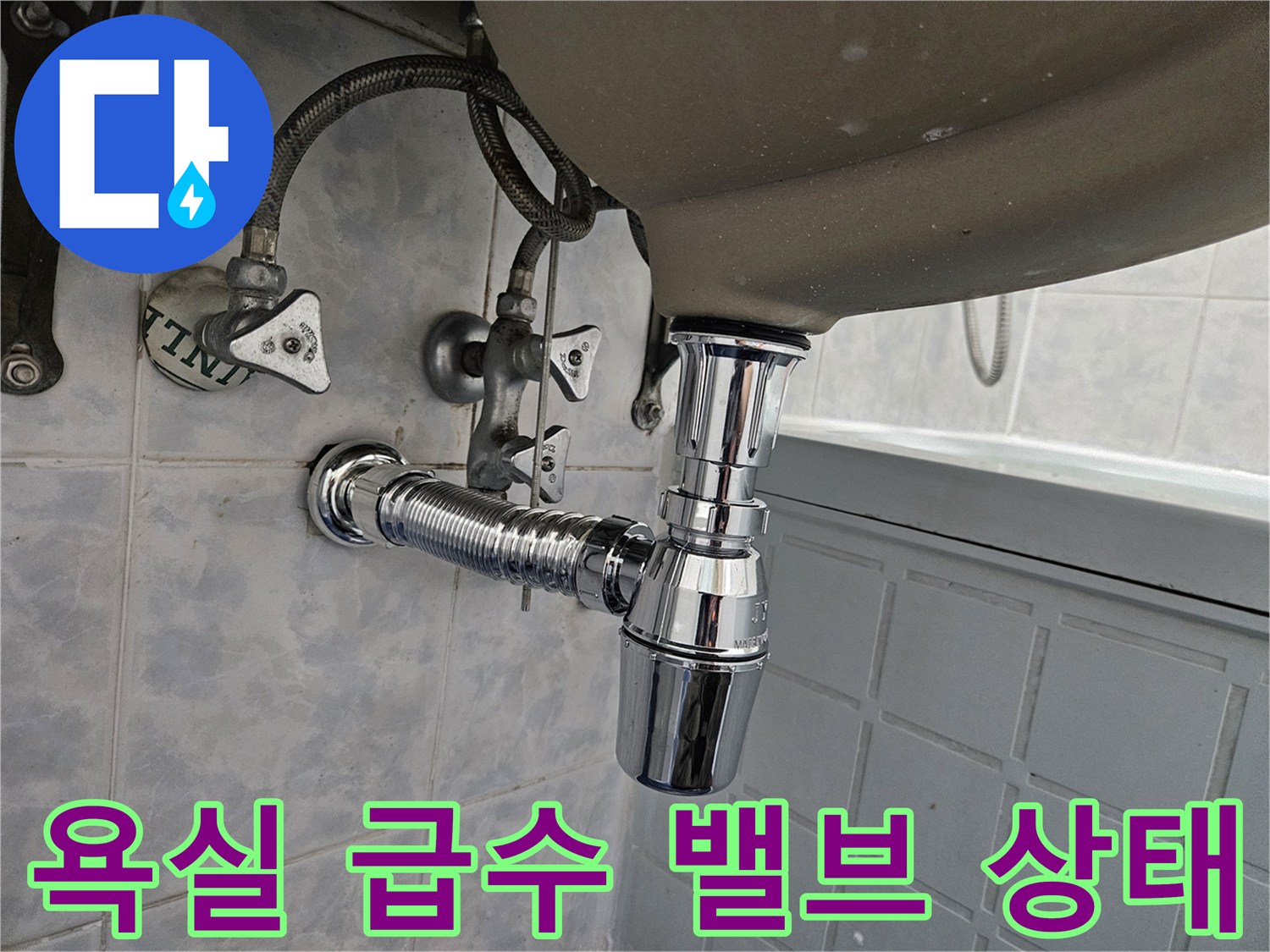 벽면에 설치된 급수 밸브와 세면대 연결 호스 사진입니다.