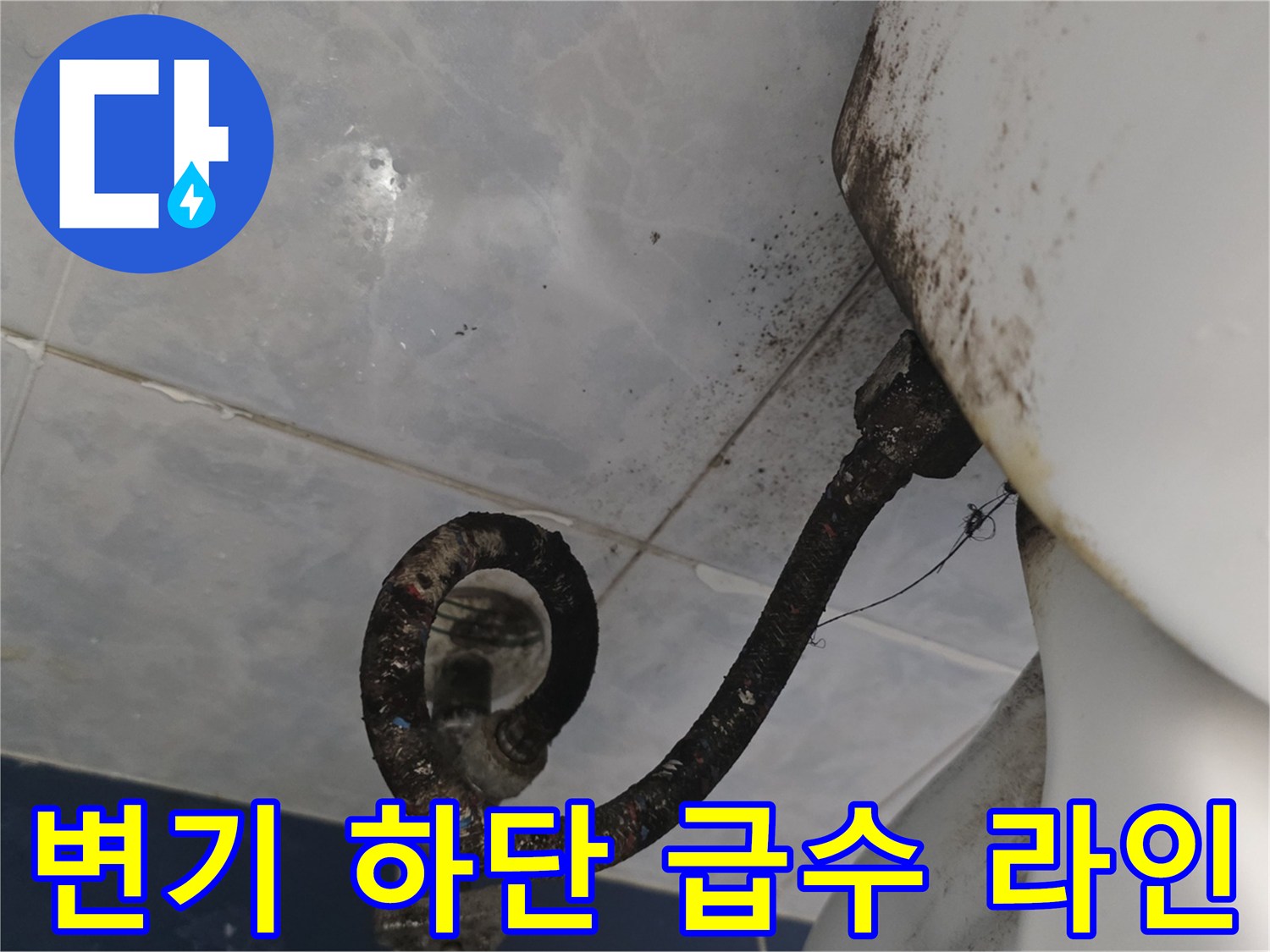 변기 뒤쪽 배관 주변의 어두운 습기 자국
