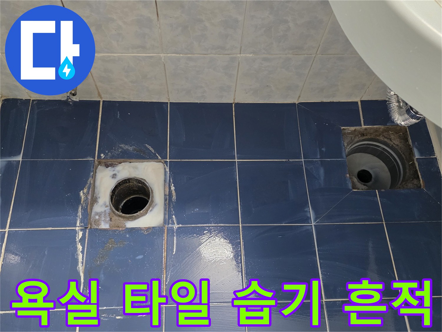 습기가 맺혀 있는 파란색 욕실 타일과 배수구 부위