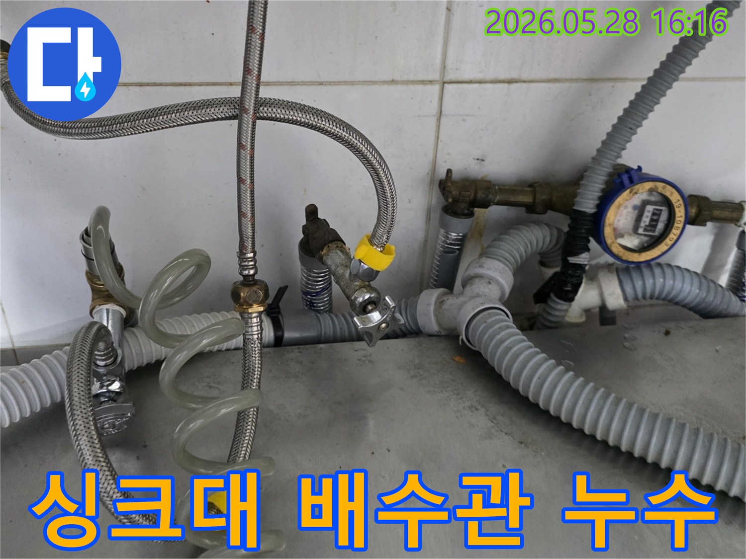 싱크대 하부의-회색 주름 배수 호스에서-누수가 발생하여-전문가가-점검하는 모습