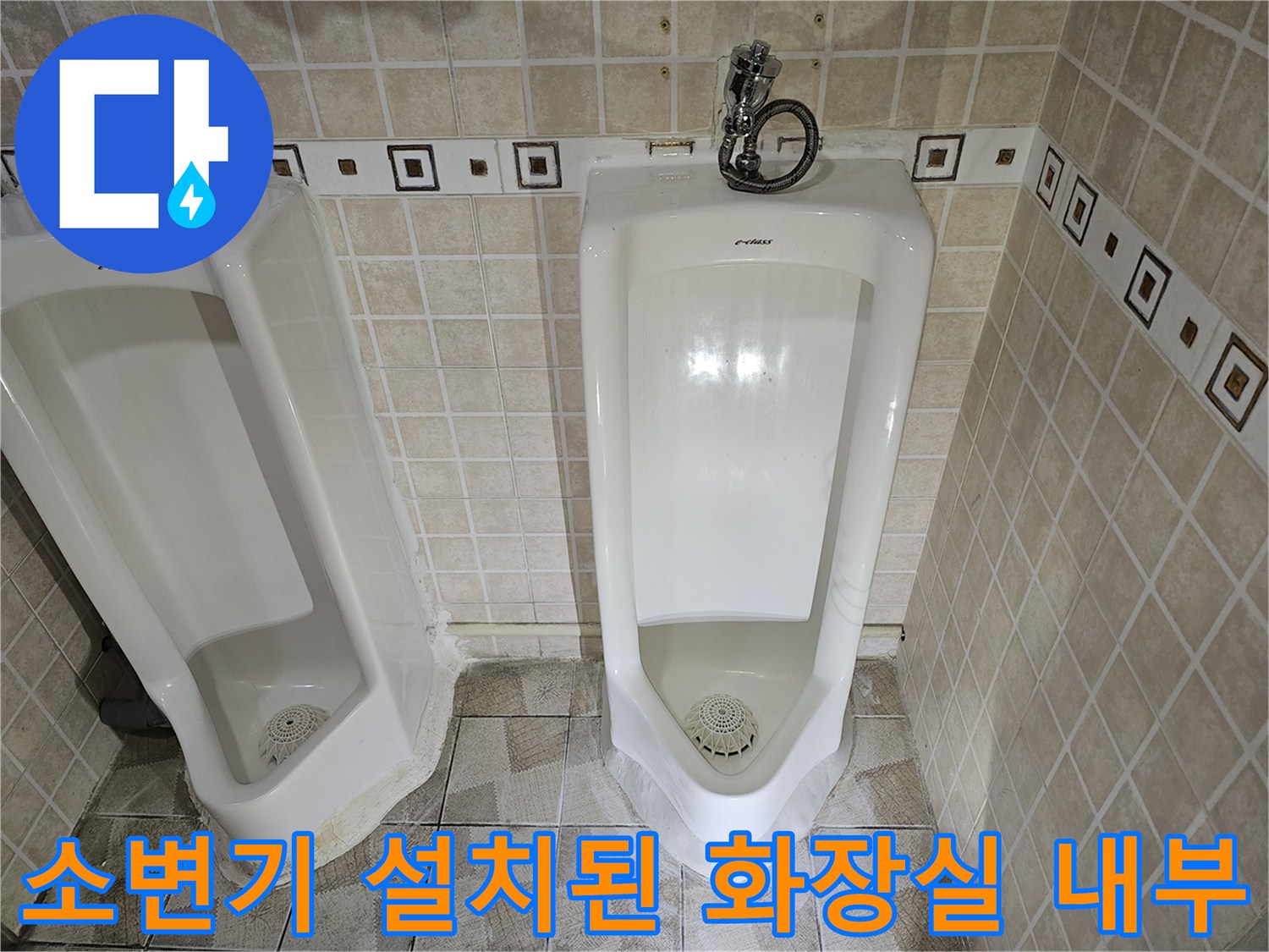 사무실 내부에 설치된 소변기와 타일 벽면의 모습입니다.