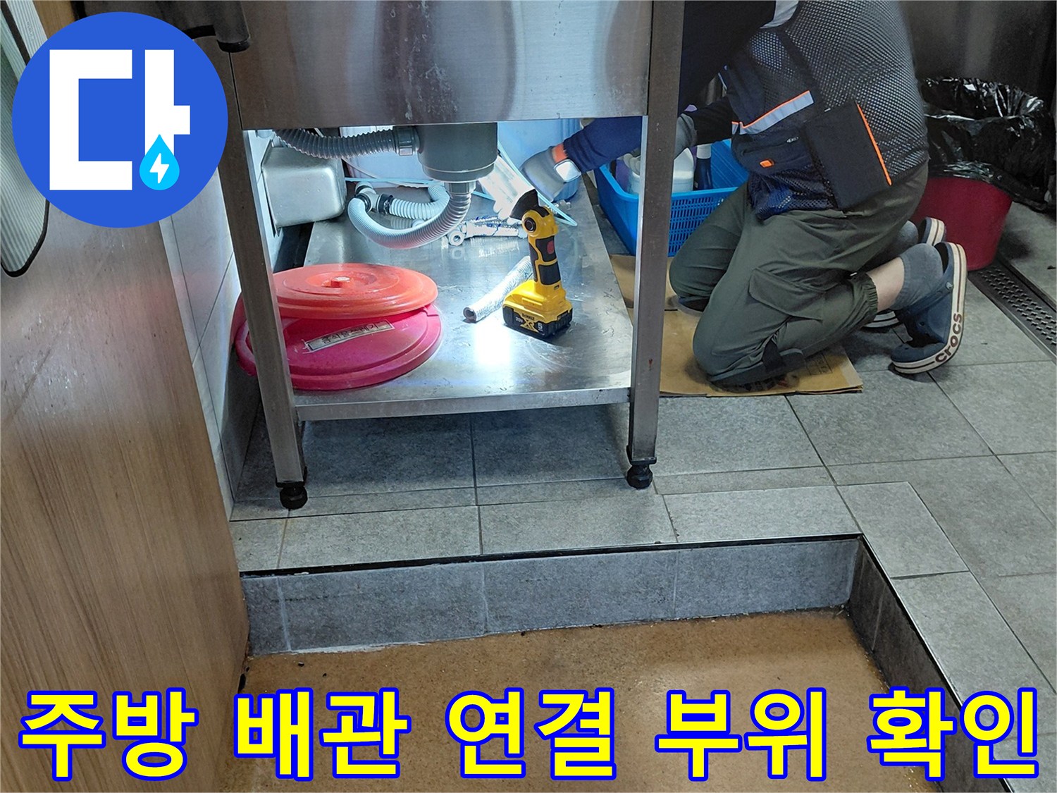싱크대-아래쪽-에이콘-배관의-누수-지점을-찾는-작업자