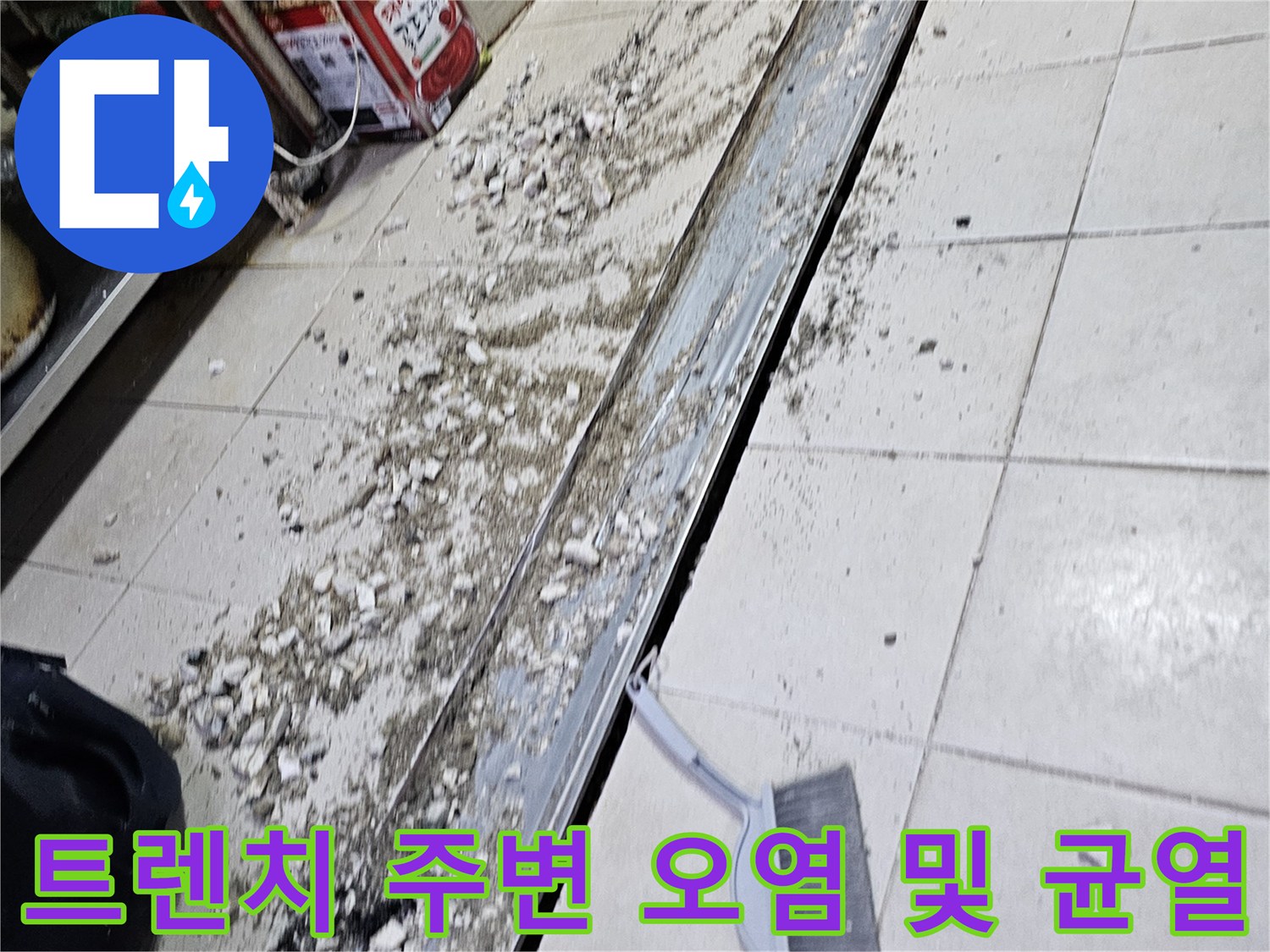 배수 트렌치 테두리의 파손된 마감재와 타일 틈새 모습